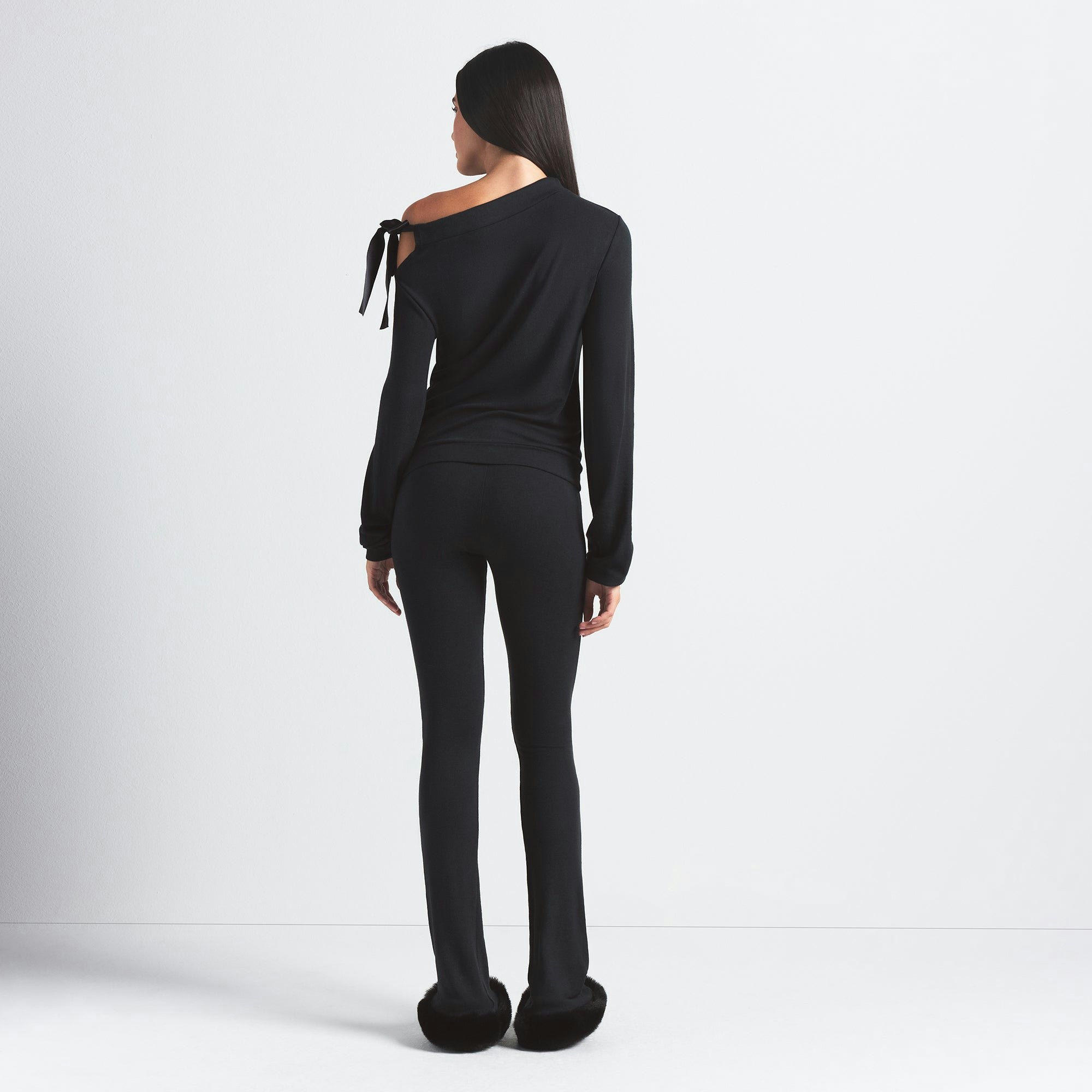 SKIMS CLOUD SLIM FLARE PANT | ONYX ON A MODEL BACK VIEW @ | FOCUS: 0.0, 1.0, 0.9