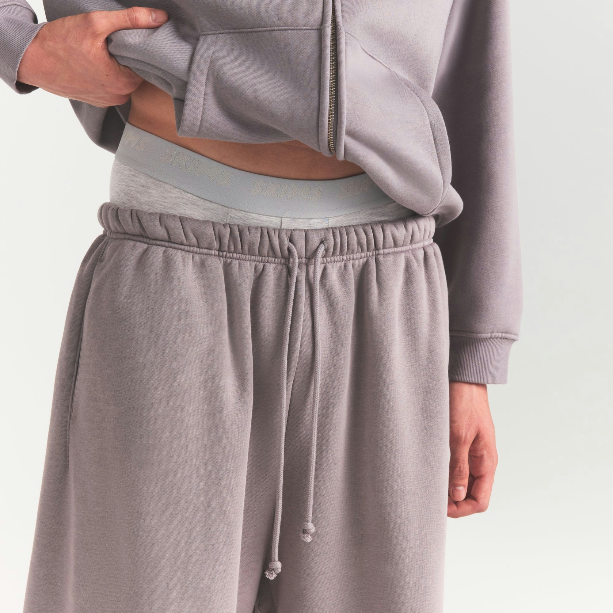 FLEECE LOUNGE MENS RELAXED LONG SHORT | SHADOW ON A MODEL SIDE VIEW @ | FOCUS: 0.0, 1.0, 0.9