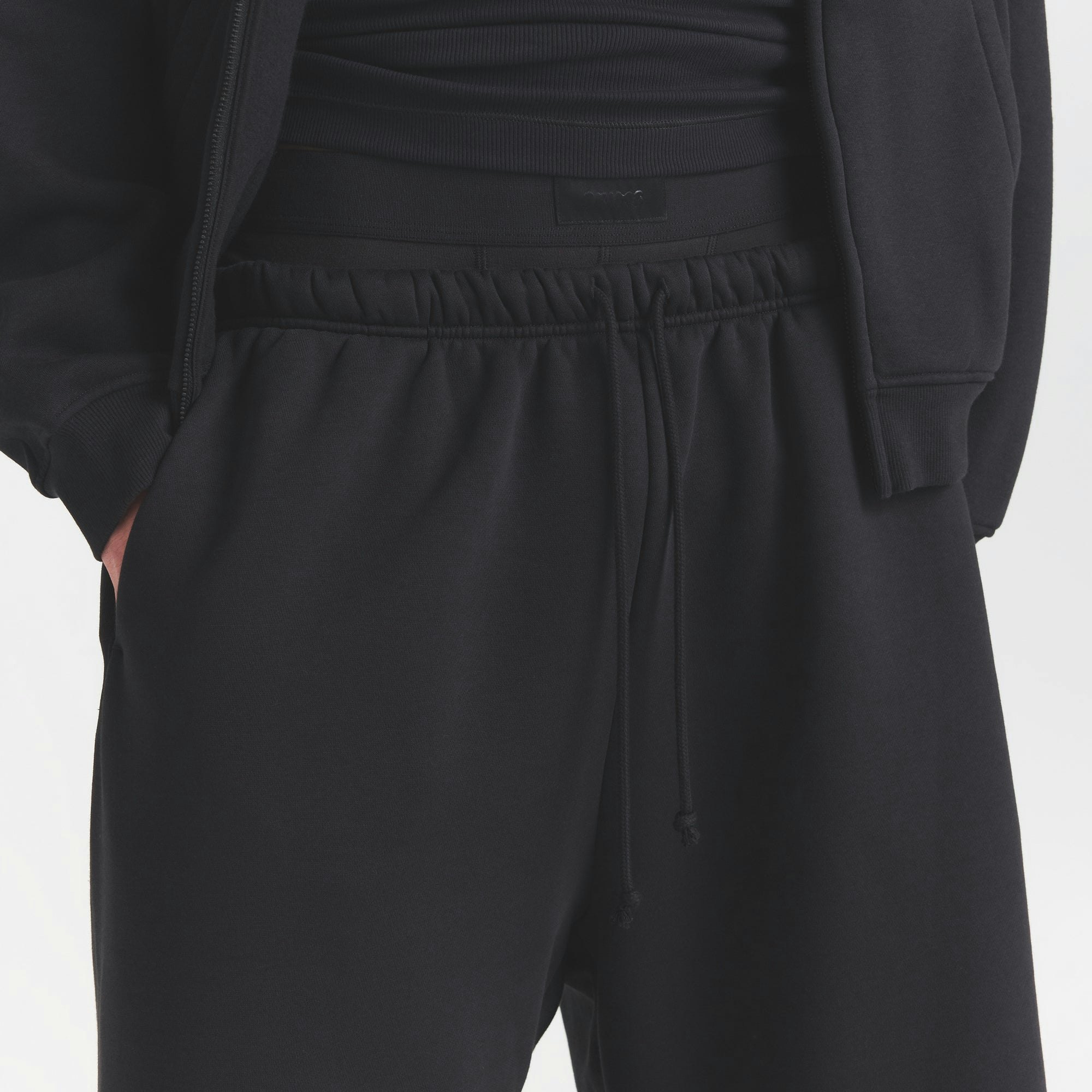 FLEECE LOUNGE MENS RELAXED LONG SHORT | WASHED ONYX ON A MODEL SIDE VIEW @ | FOCUS: 0.0, 1.0, 0.9