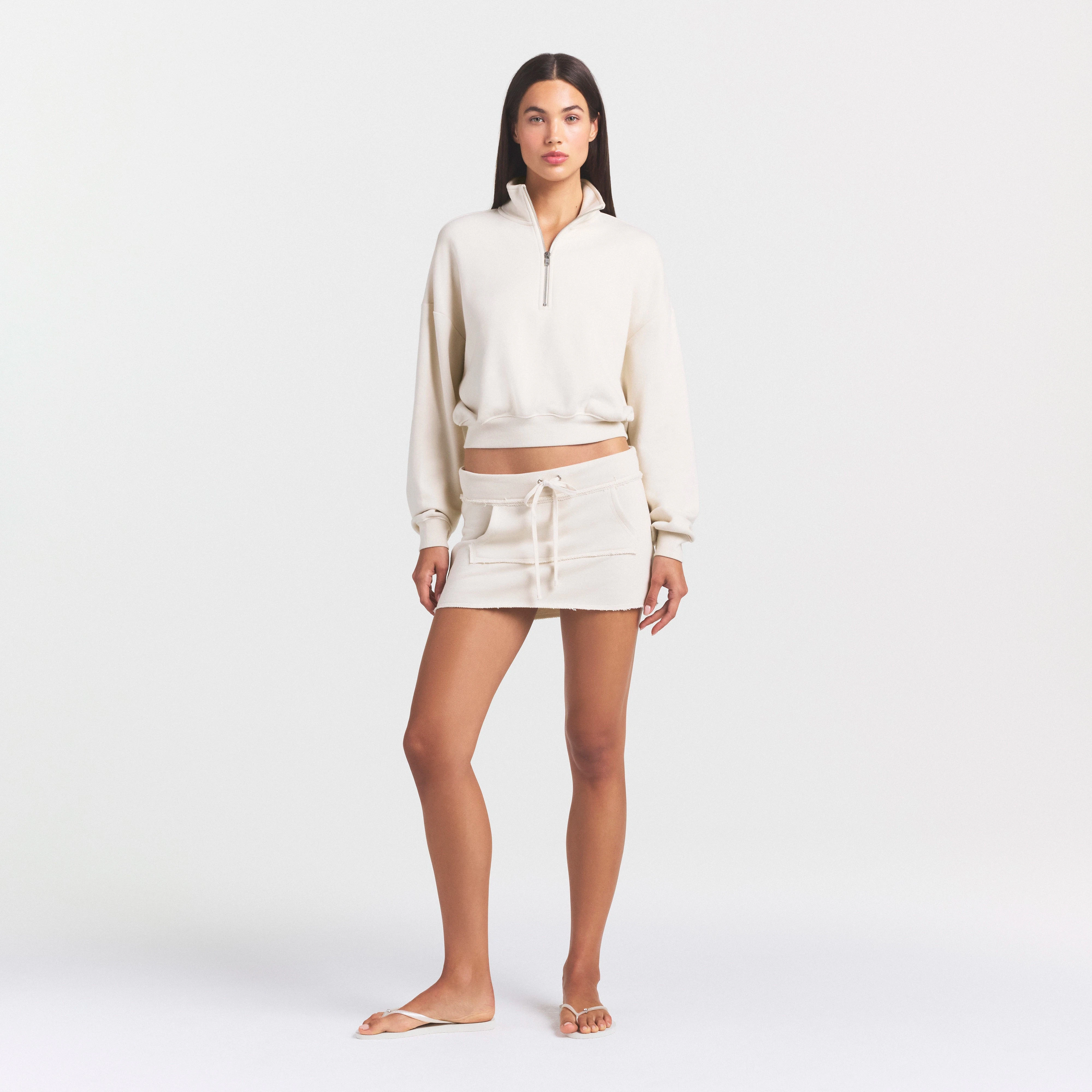 DRAPEY FRENCH TERRY MINI SKIRT | BUFF ON A MODEL FRONT VIEW @ | FOCUS: 0.0, 1.0, 0.9