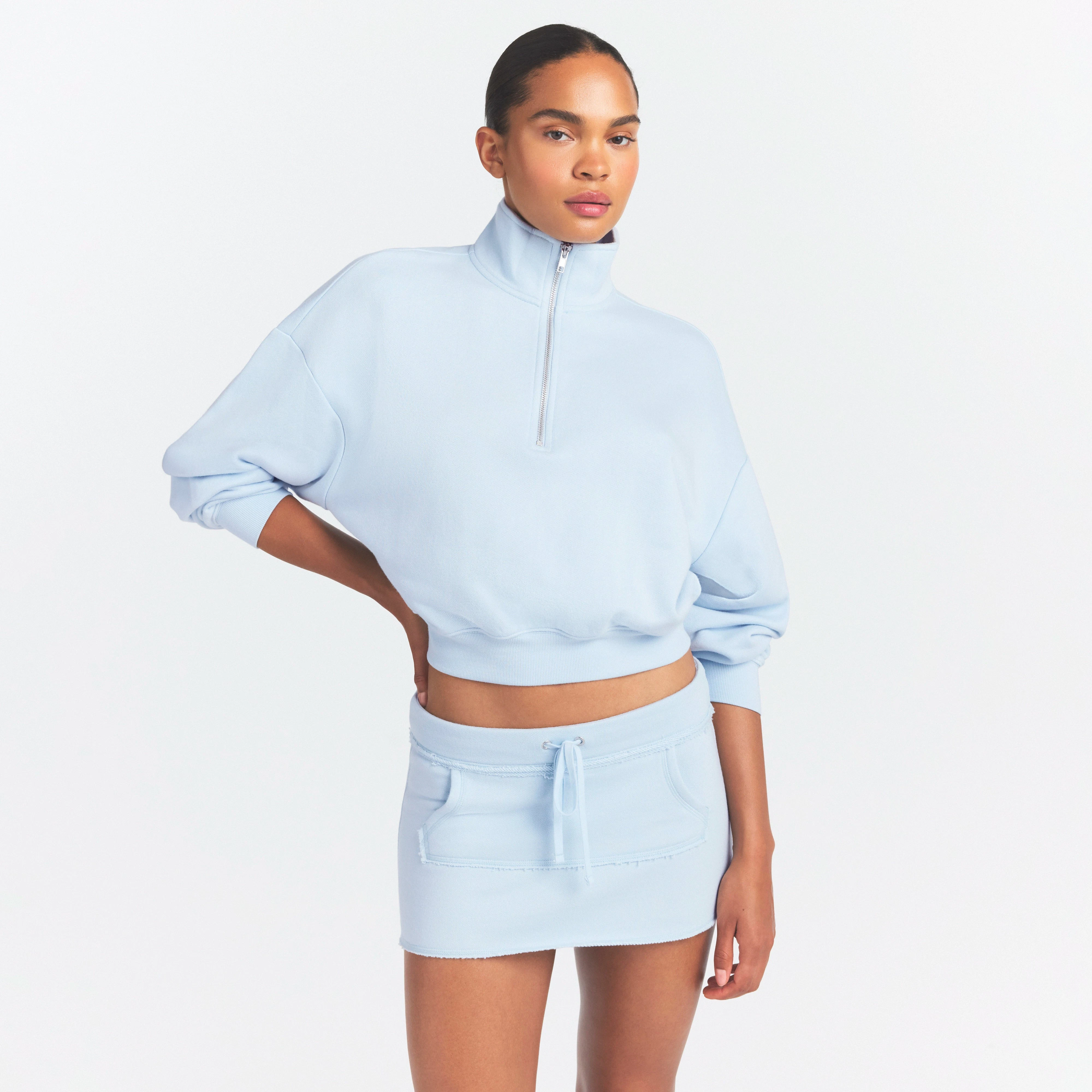 DRAPEY FRENCH TERRY MINI SKIRT | POWDER BLUE ON A MODEL SIDE VIEW @ | FOCUS: 0.0, 1.0, 0.9
