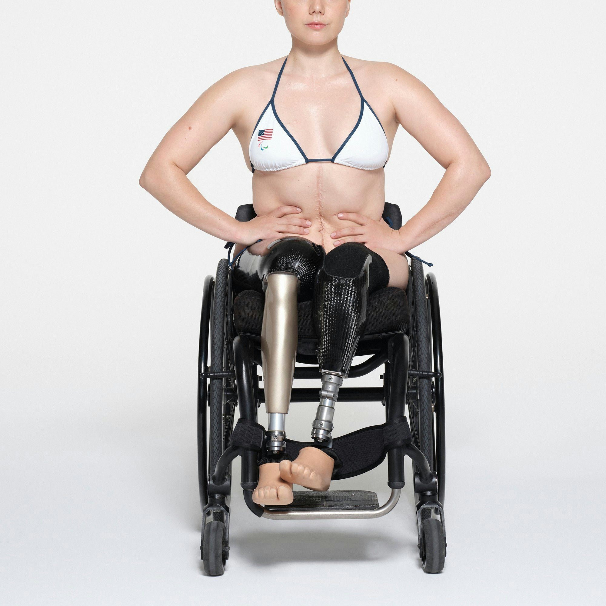 SKIMS FOR TEAM USA SIGNATURE SWIM PARALYMPIC TRIANGLE TOP | WHITE ON A MODEL FRONT VIEW | FOCUS: 0.1, 1, 0.9