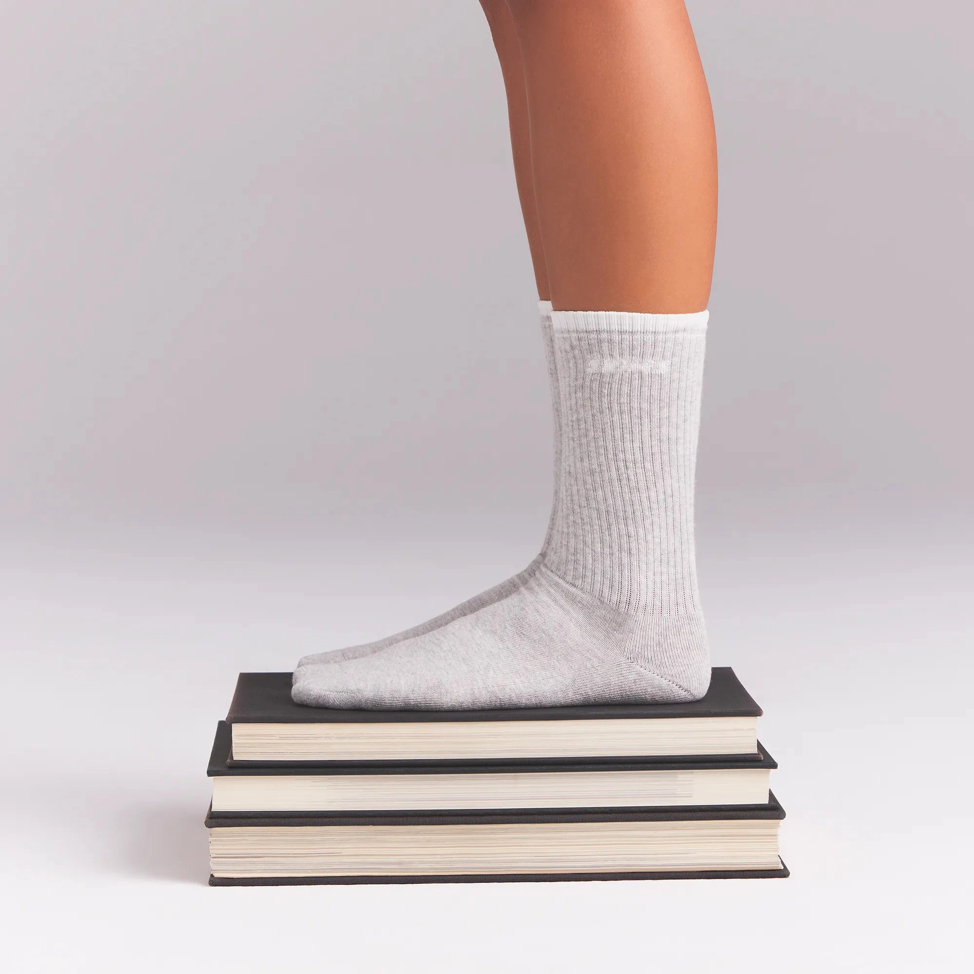 RIBBED QUARTER CREW LOGO SOCK | LIGHT HEATHER GREY AND SNOW ON A MODEL | FOCUS: 0.0, 1.0, 0.9