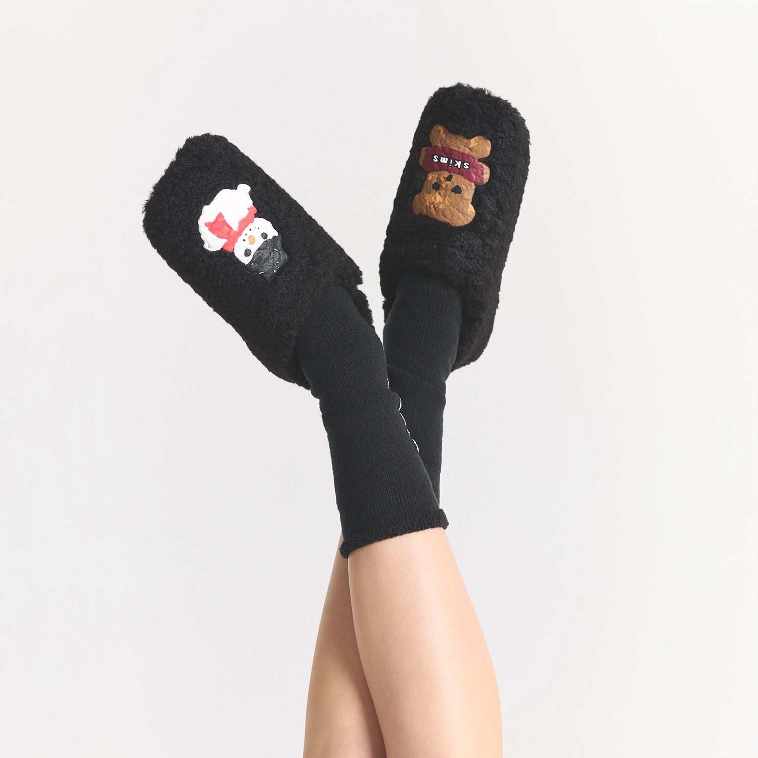 CACTUS PLANT FLEA MARKET X SKIMS SHERPA SLIPPER | ONYX GINGERBREAD SNOWMAN PRINT ON A MODEL SIDE VIEW FOCUS: 0.0, 1.0, 0.9