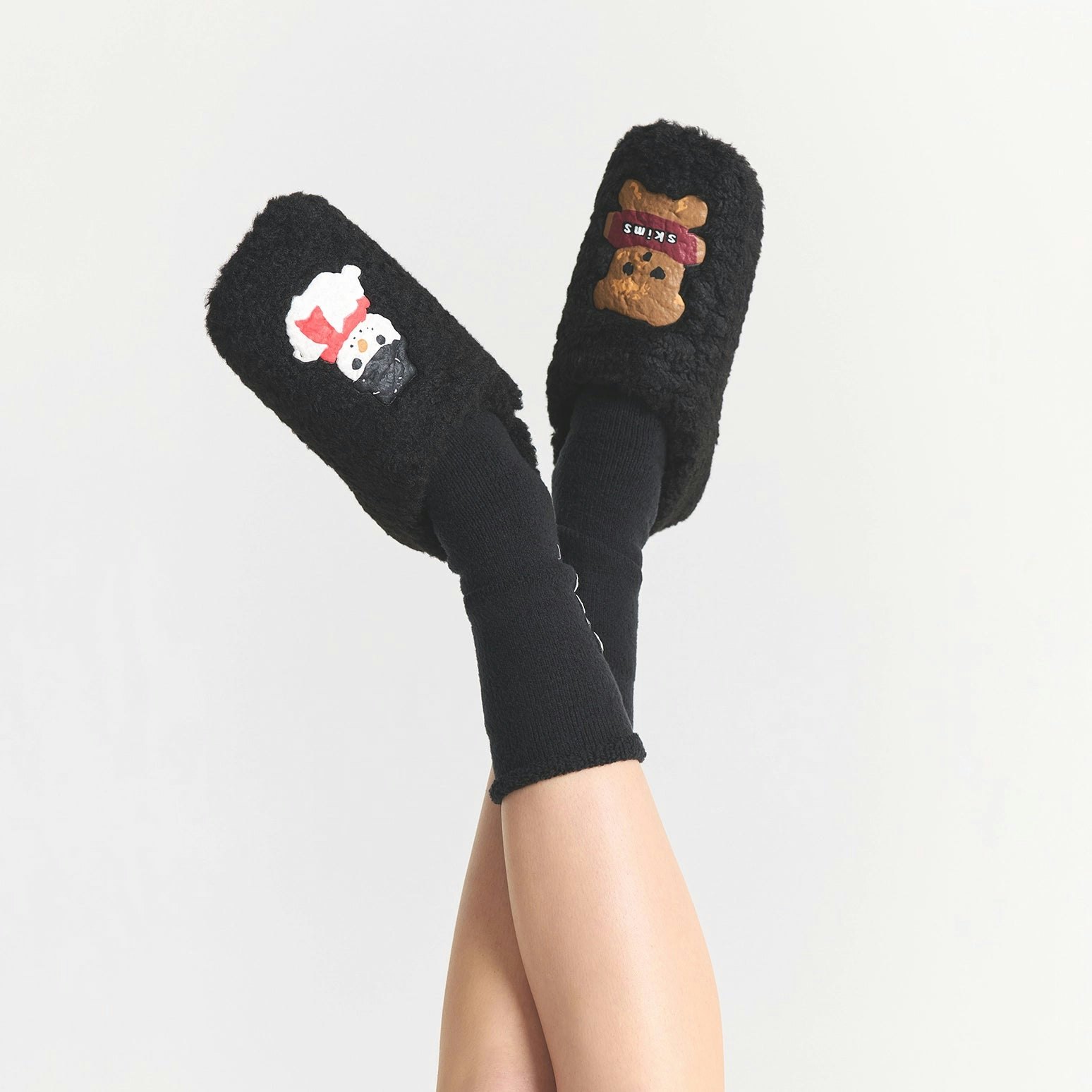 CACTUS PLANT FLEA MARKET X SKIMS SHERPA SLIPPER | ONYX GINGERBREAD SNOWMAN PRINT ON A MODEL SIDE VIEW FOCUS: 0.0, 1.0, 0.9