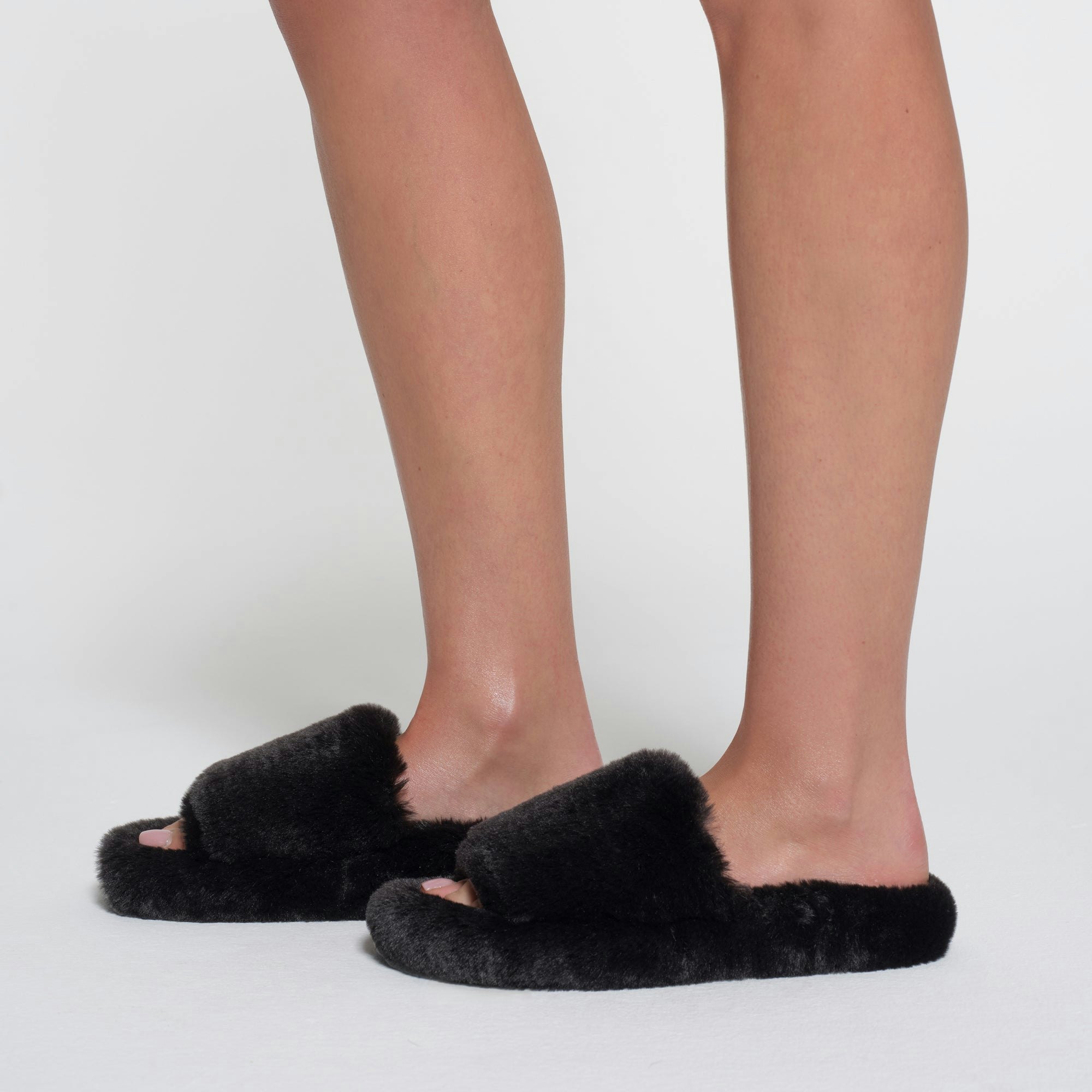 FAUX FUR SLIPPER | ONYX ON A MODEL SIDE VIEW