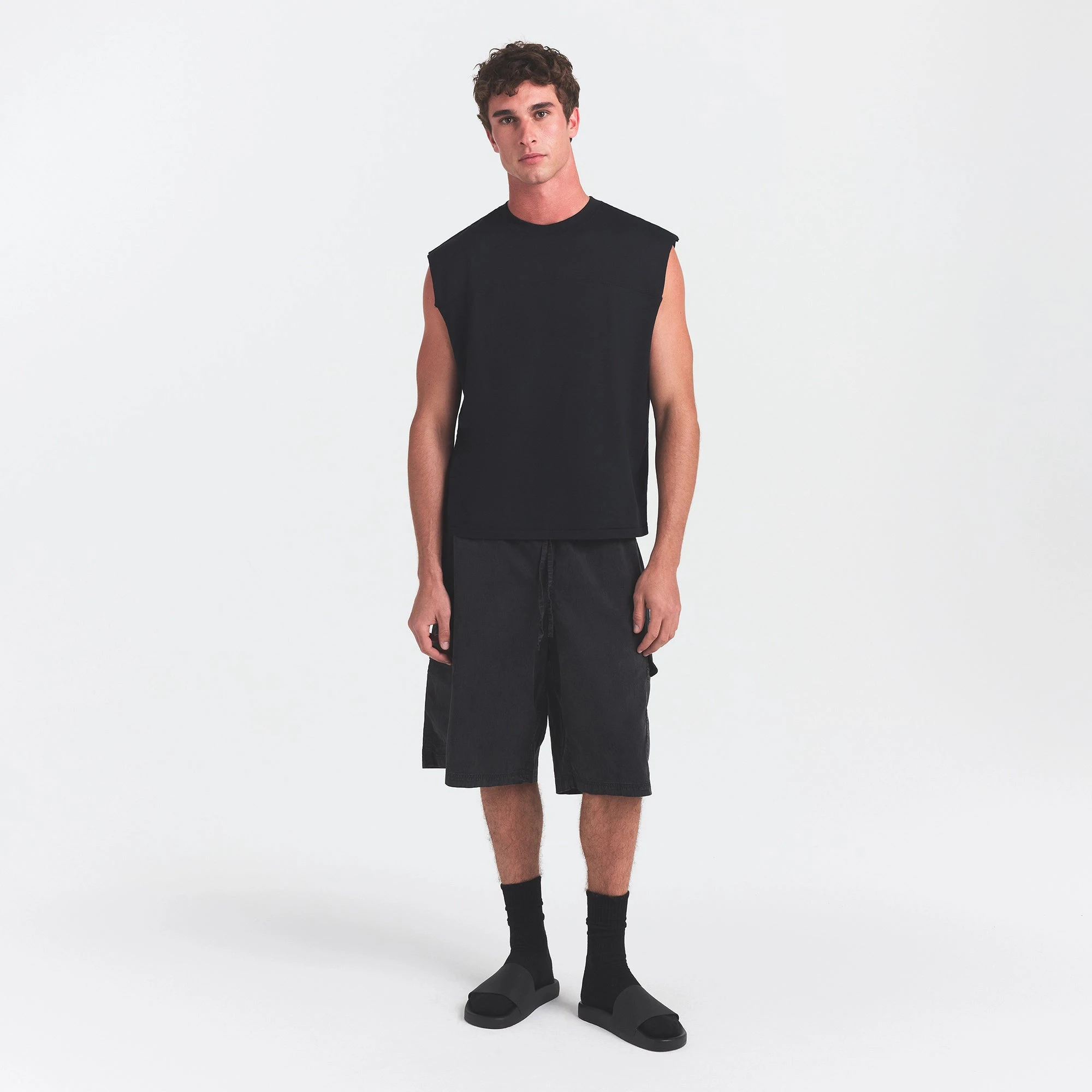 SKIMS ACCESSORIES MENS POOL SLIDE | ONYX ON A MODEL FRONT VIEW @ | FOCUS: 0.0, 1.0, 0.9