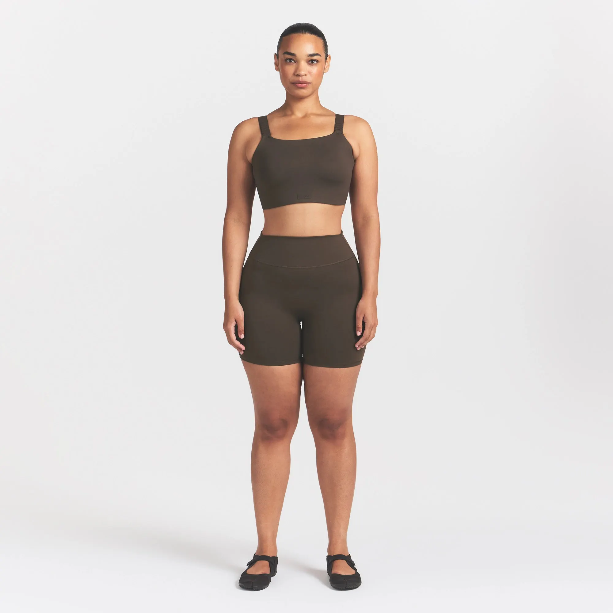 NikeSKIMS MATTE WIDE STRAP BRA | DARK SEPIA ON A MODEL FRONT VIEW @ | FOCUS: 0.9, 0.1, 0.7