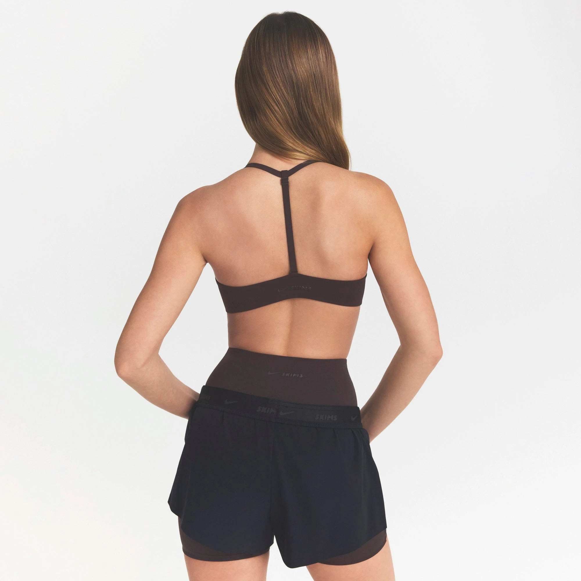 NikeSKIMS STUDIO STRETCH T-BACK TRIANGLE BRA | DARK ROASTON A MODEL FRONT VIEW @ | FOCUS: 0.0, 1.0, 0.9