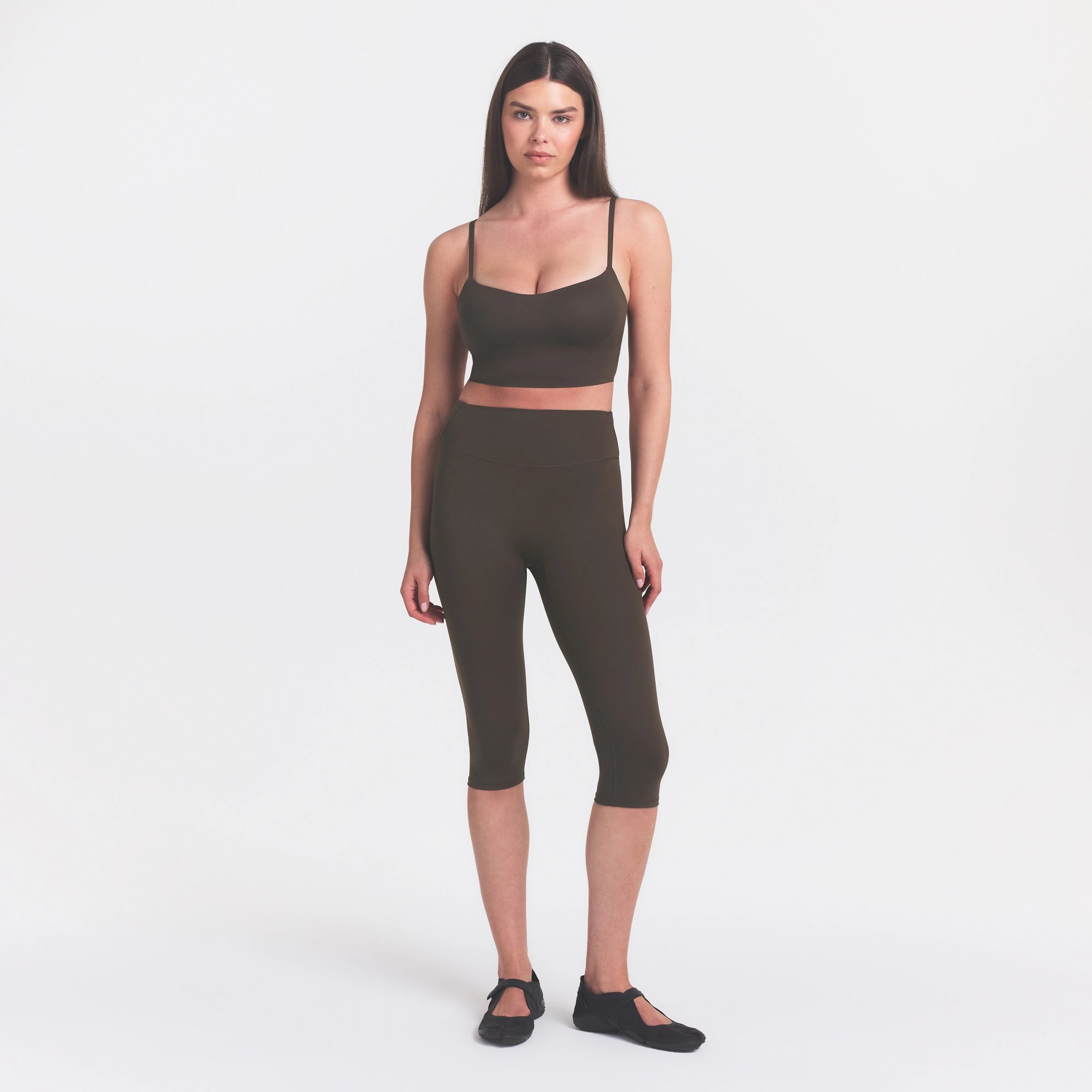 NikeSKIMS MATTE CROP 17" LEGGING | DARK SEPIA ON A MODEL FRONT VIEW @ | FOCUS: 0.0, 1.0, 0.9