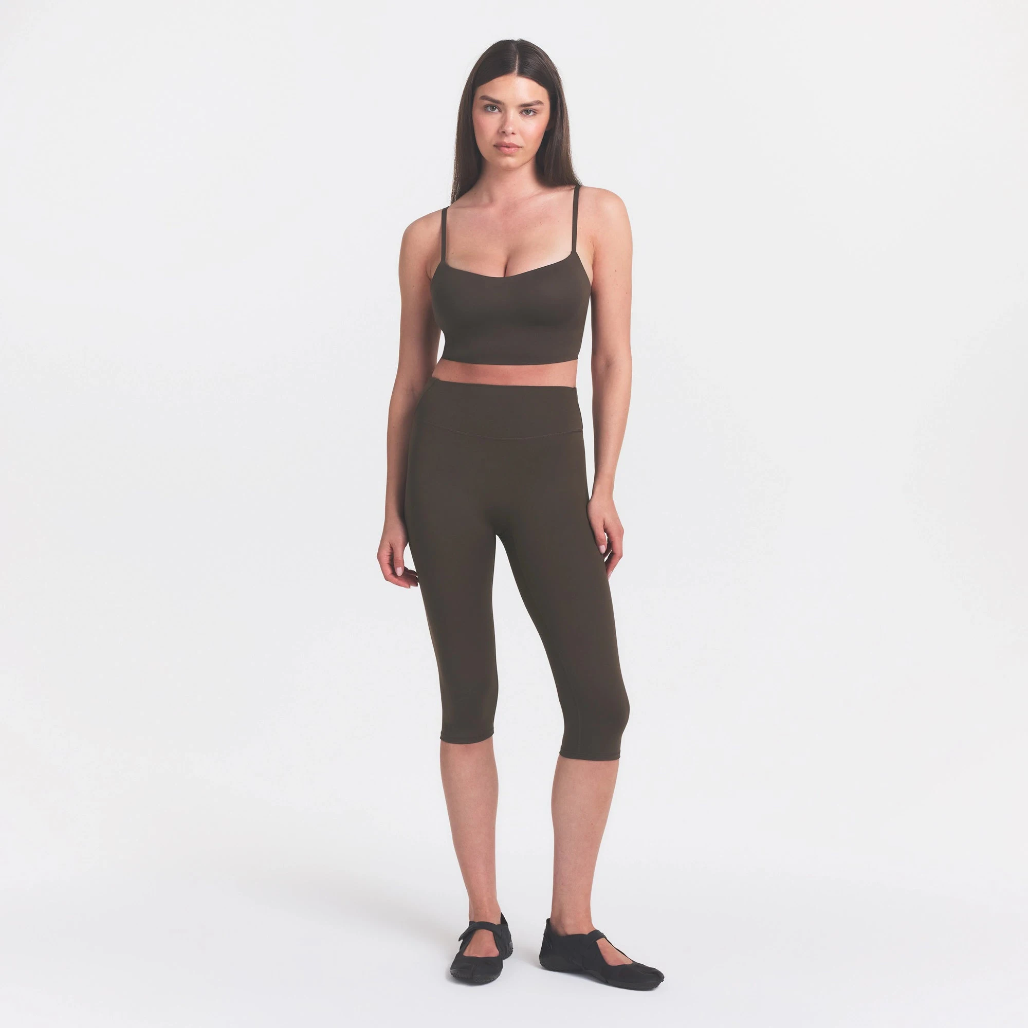 NikeSKIMS MATTE CROP 17" LEGGING | DARK SEPIA ON A MODEL FRONT VIEW @ | FOCUS: 0.0, 1.0, 0.9