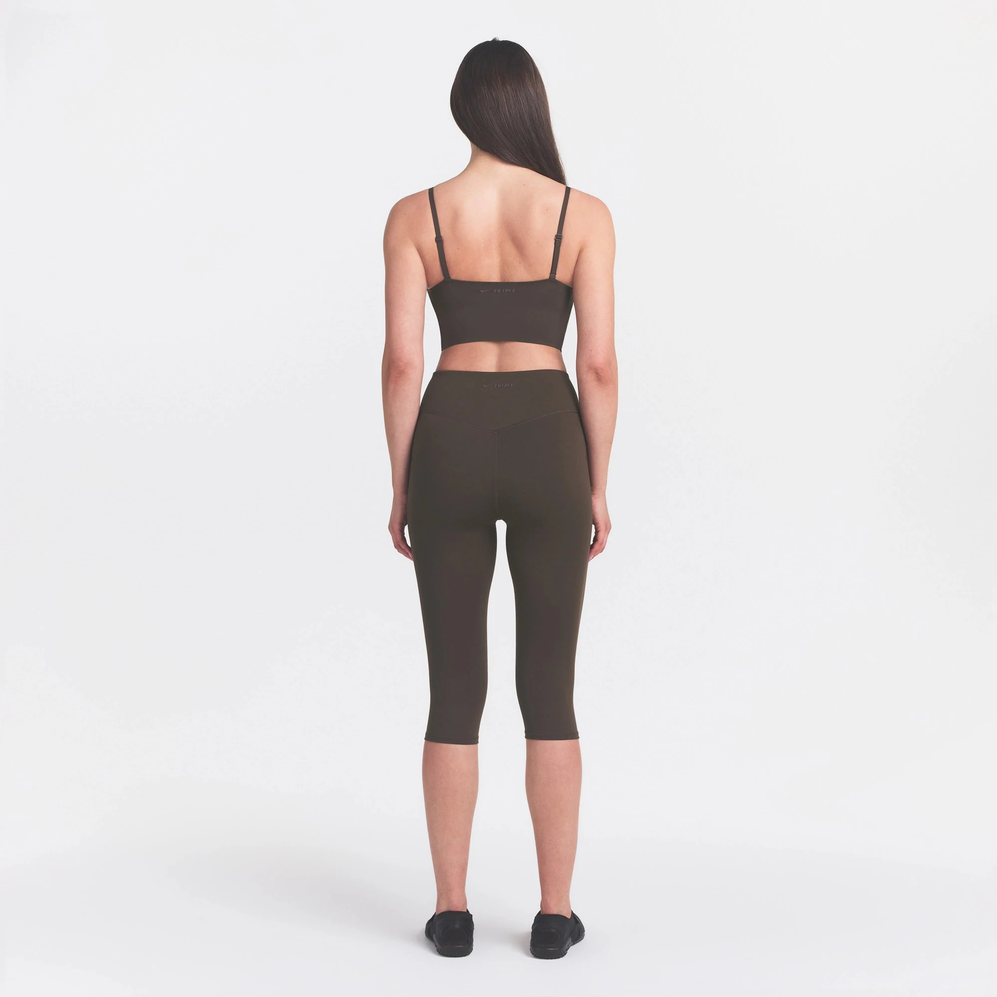 NikeSKIMS MATTE CROP 17" LEGGING | DARK SEPIA ON A MODEL FRONT VIEW @ | FOCUS: 0.0, 1.0, 0.9