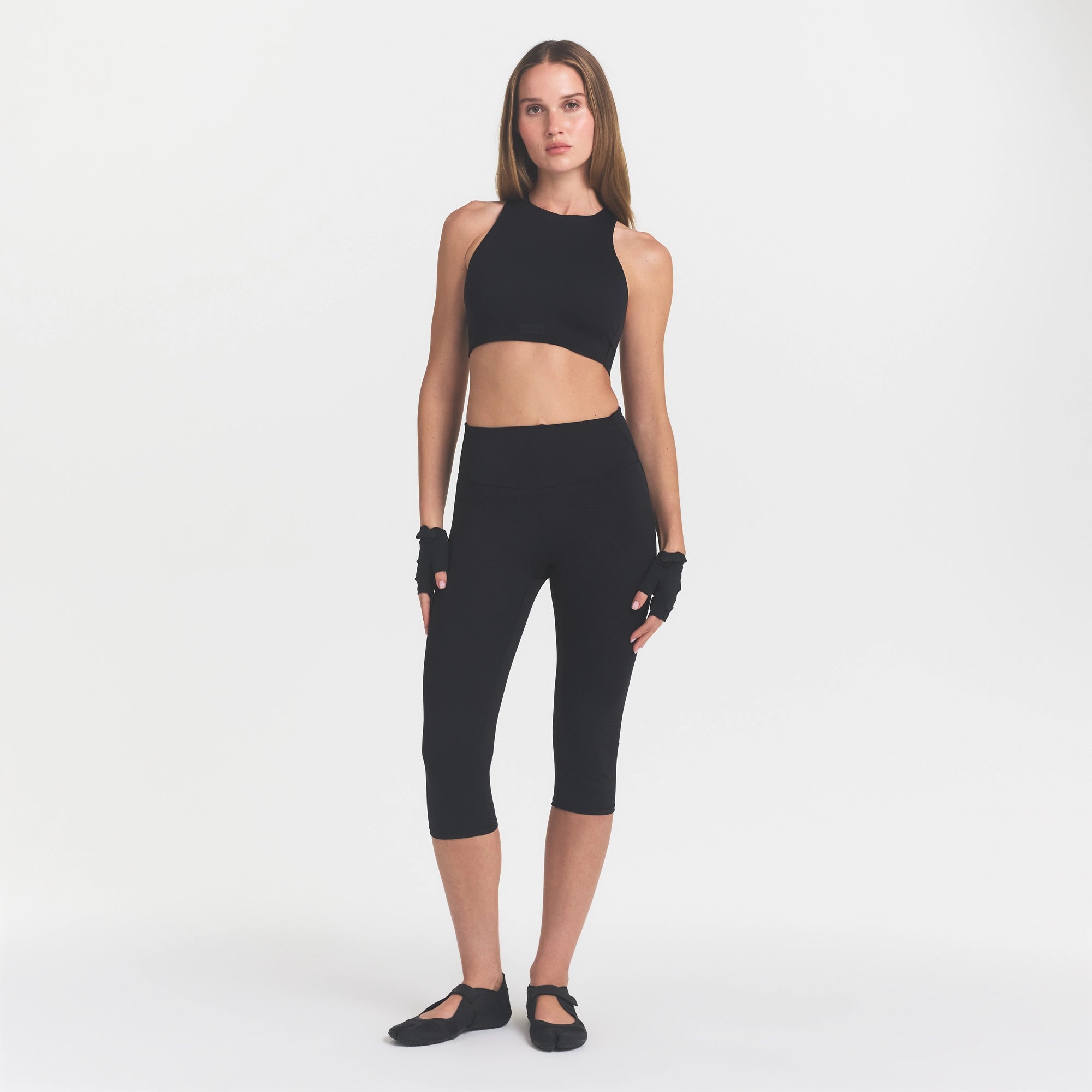 NikeSKIMS MATTE CROP 17" LEGGING | OBSIDIAN ON A MODEL FRONT VIEW @ | FOCUS: 0.0, 1.0, 0.9