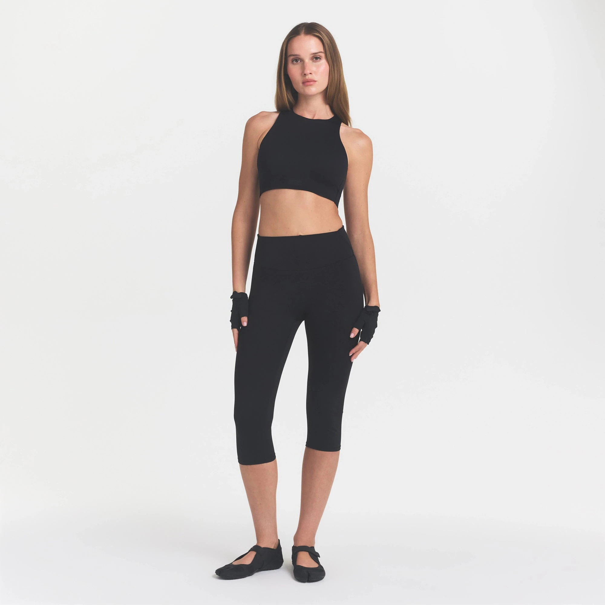 NikeSKIMS MATTE CROP 17" LEGGING | OBSIDIAN ON A MODEL FRONT VIEW @ | FOCUS: 0.0, 1.0, 0.9