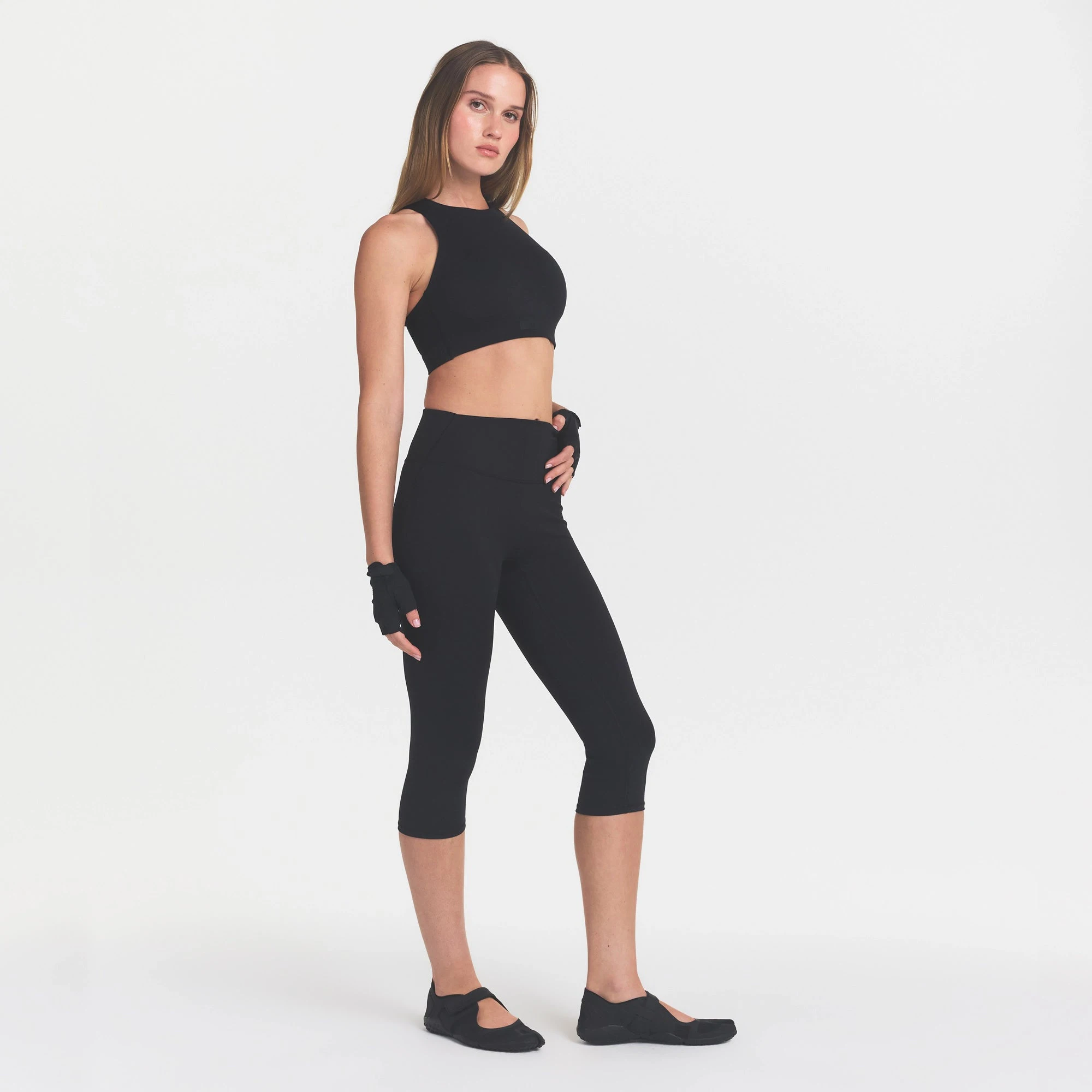 NikeSKIMS MATTE CROP 17" LEGGING | OBSIDIAN ON A MODEL FRONT VIEW @ | FOCUS: 0.0, 1.0, 0.9