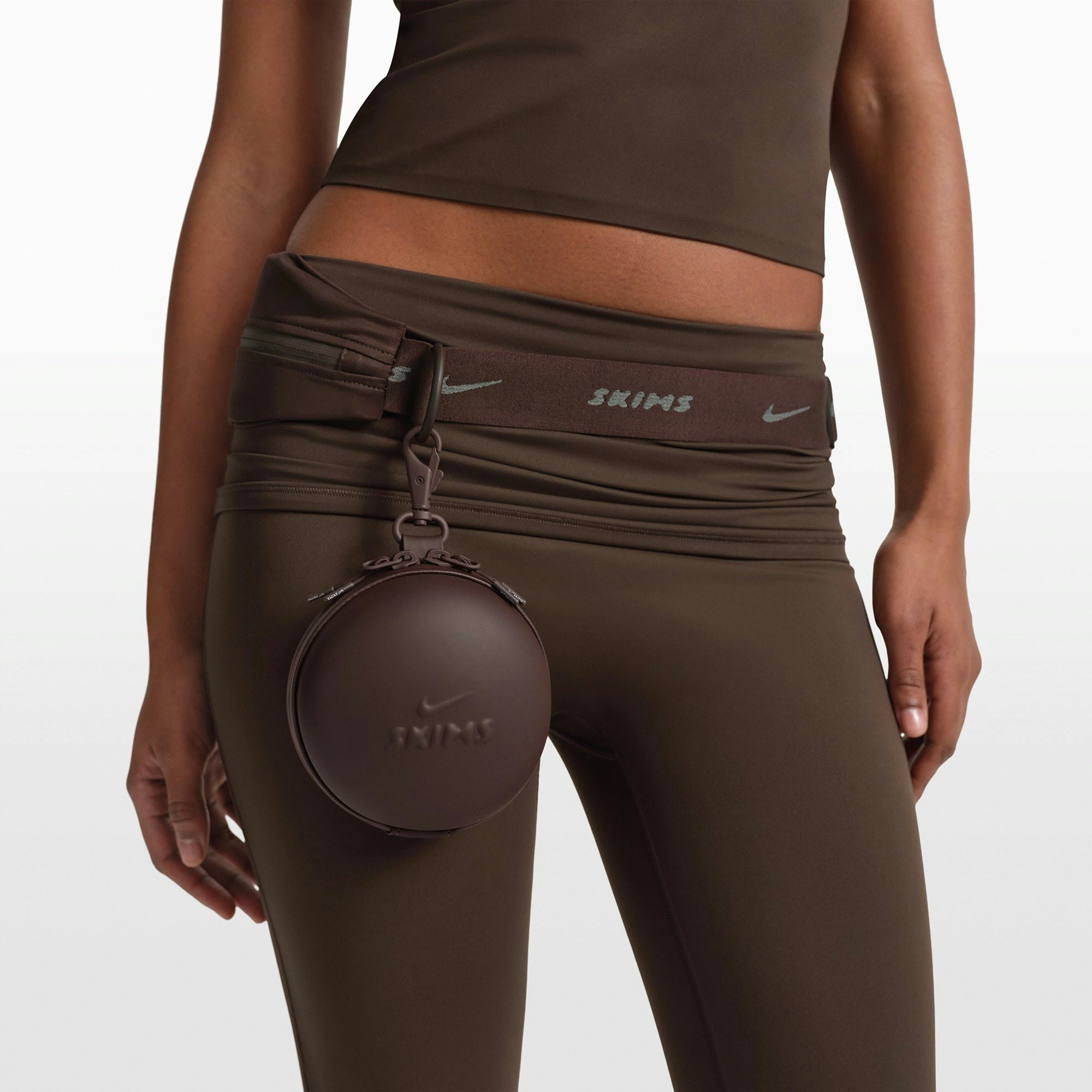 NikeSKIMS ACCESSORIES HARDSHELL ROUND CASE | PHOENIX ON A MODEL FRONT VIEW @ | FOCUS: 0.0, 1.0, 0.9