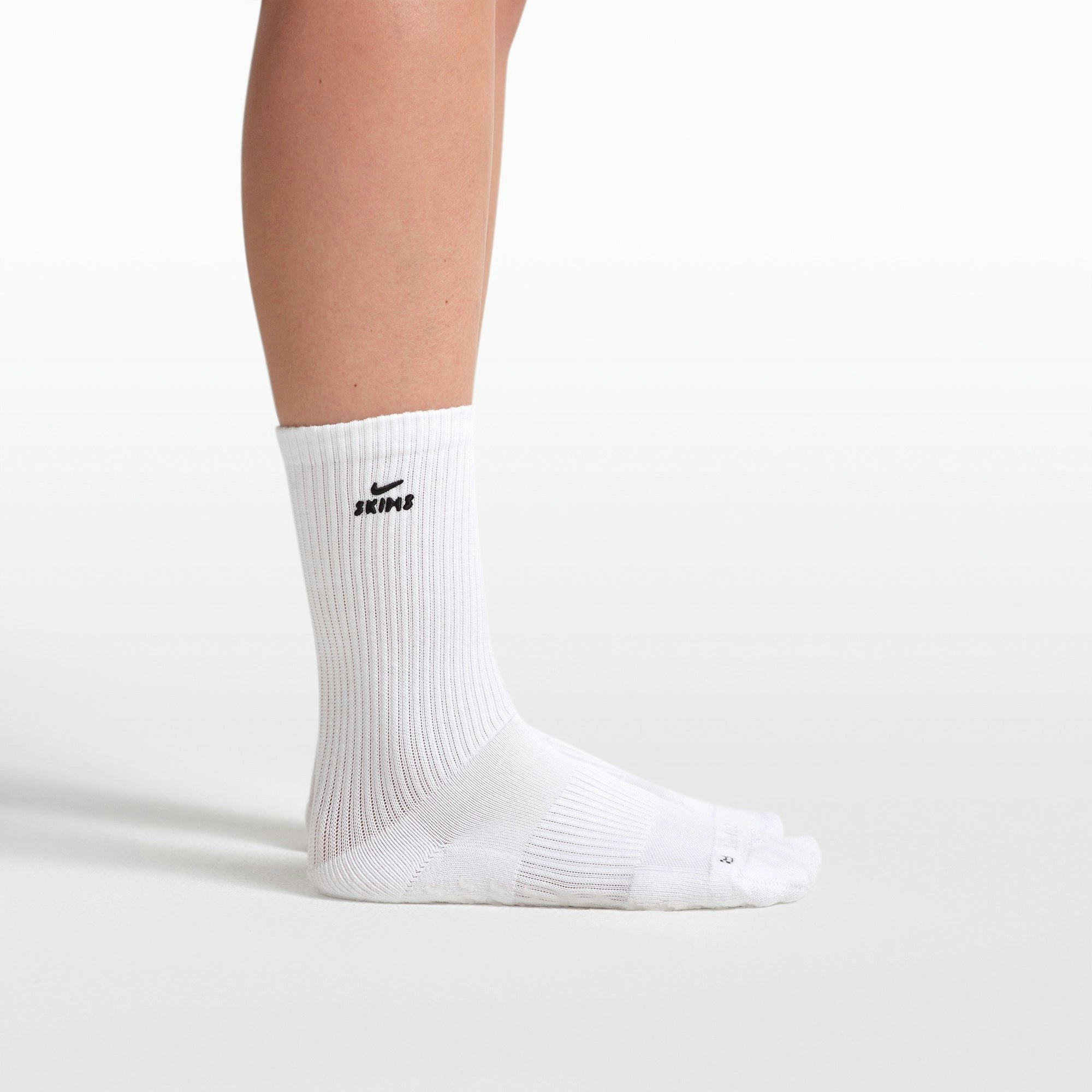 NikeSKIMS ACCESSORIES DRI-FIT PILATES GRIP CREW SOCK | SNOW FLAT ON A WHITE BACKGROUND