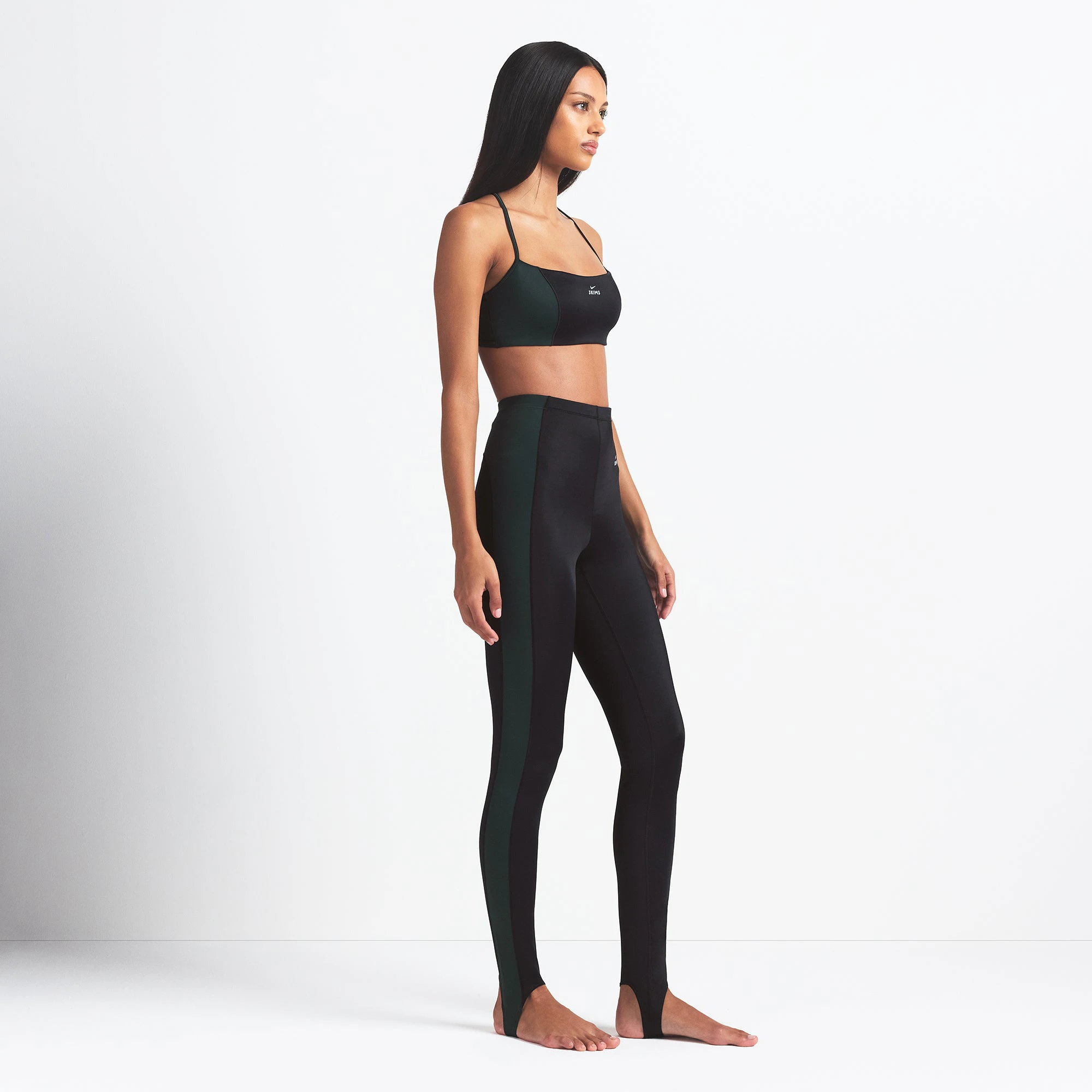 NikeSKIMS SHINE DRAWCORD STIRRUP 26" LEGGING | OBSIDIAN AND DARK TEAL ON A MODEL SIDE VIEW @ | FOCUS: 0.0, 1.0, 0.9