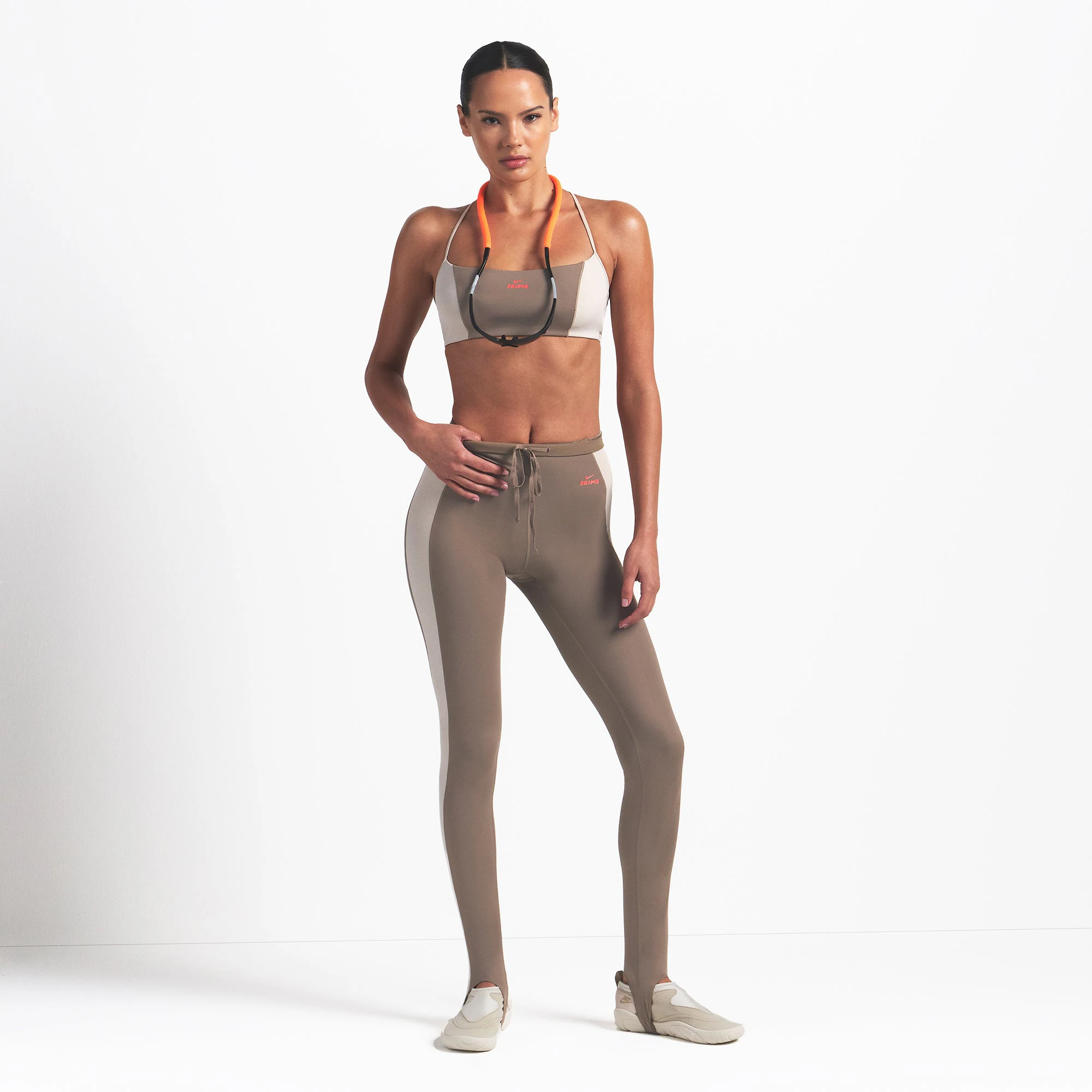NikeSKIMS SHINE DRAWCORD STIRRUP 26" LEGGING | TRUFFLE AND STONE ON A MODEL FRONT VIEW @ | FOCUS: 0.0, 1.0, 0.9