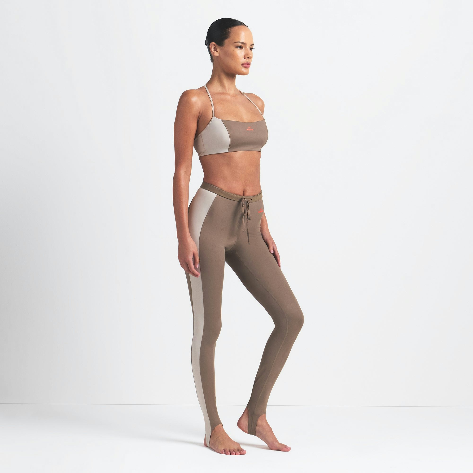 NikeSKIMS SHINE DRAWCORD STIRRUP 26" LEGGING | TRUFFLE AND STONE ON A MODEL SIDE VIEW @ | FOCUS: 0.0, 1.0, 0.9