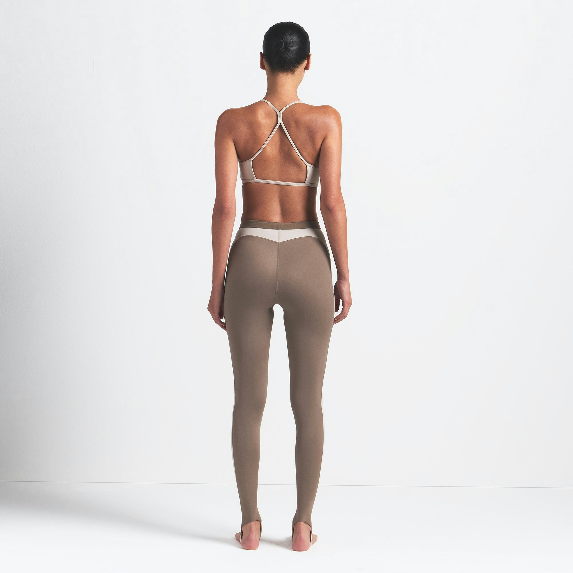 NikeSKIMS SHINE DRAWCORD STIRRUP 26" LEGGING | TRUFFLE AND STONE ON A MODEL BACK VIEW @ | FOCUS: 0.0, 1.0, 0.9