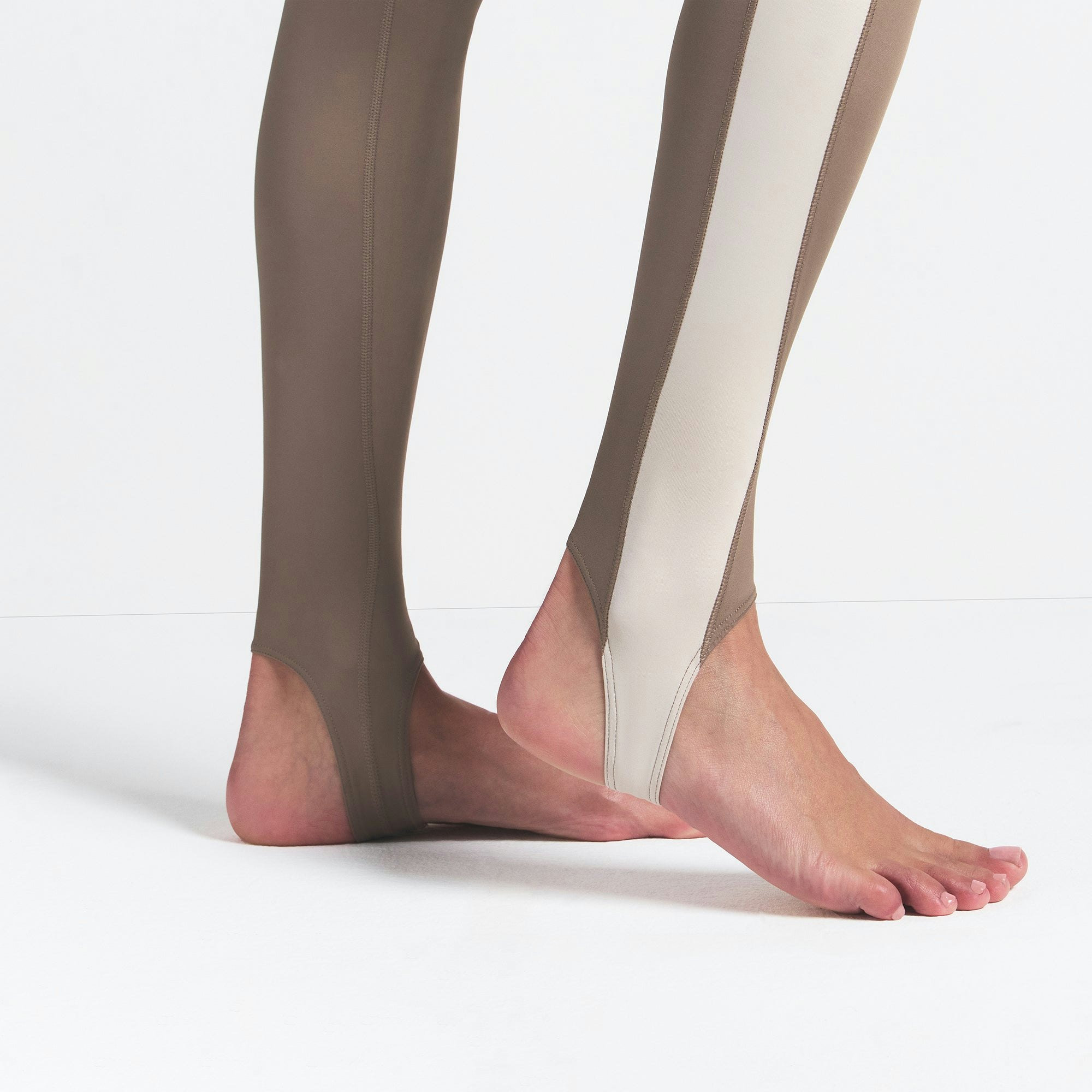 NikeSKIMS SHINE DRAWCORD STIRRUP 26" LEGGING | TRUFFLE AND STONE ON A MODEL SIDE VIEW @ | FOCUS: 0.0, 1.0, 0.9