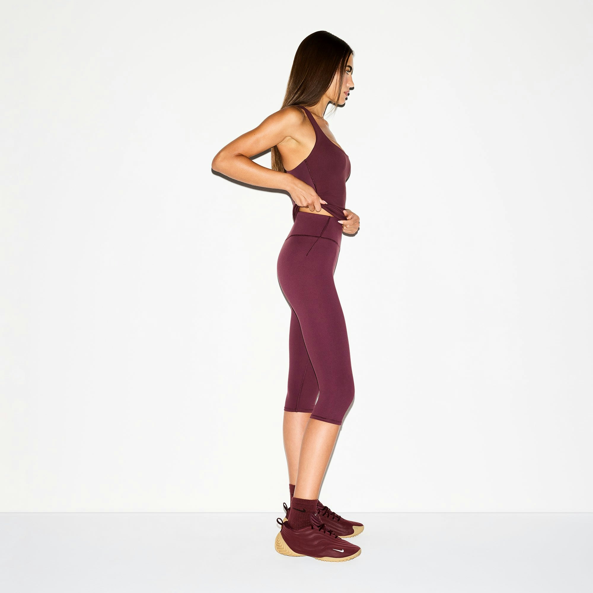 NikeSKIMS MATTE CROP 17" LEGGING | CURRANT ON A MODEL SIDE VIEW @ | FOCUS: 0.0, 1.0, 0.9