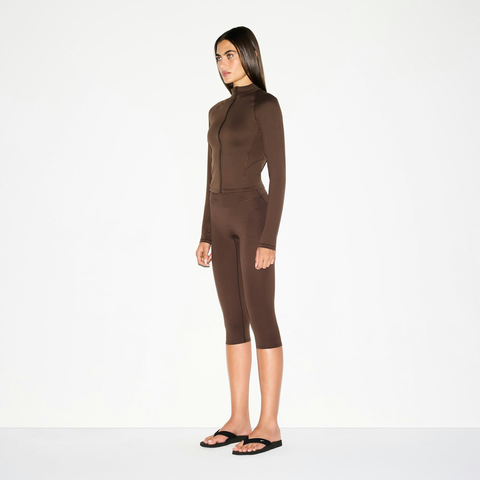 NikeSKIMS MATTE CROP 17" LEGGING | DARK SEPIA ON A MODEL SIDE VIEW @ | FOCUS: 0.0, 1.0, 0.9