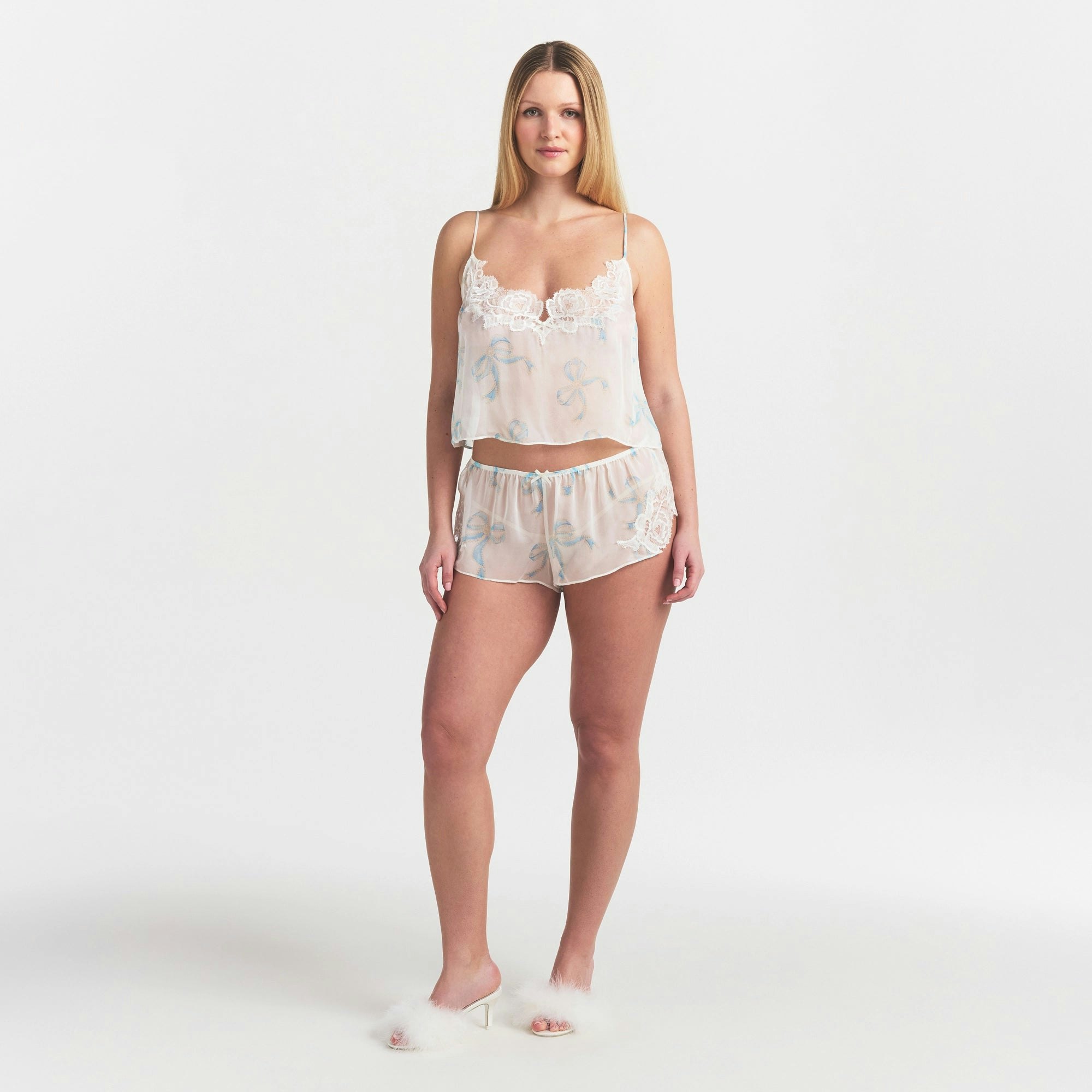 SKIMS ROMANCE CAMI AND SHORT SET | IVORY PEARL BOWS PRINT ON A MODEL FRONT VIEW @ | FOCUS: 0.0, 1.0, 0.9