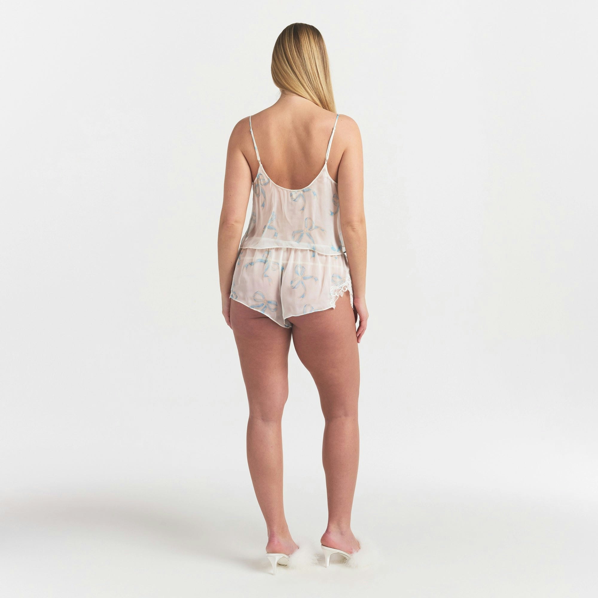 SKIMS ROMANCE CAMI AND SHORT SET | IVORY PEARL BOWS PRINT ON A MODEL FRONT VIEW @ | FOCUS: 0.0, 1.0, 0.9