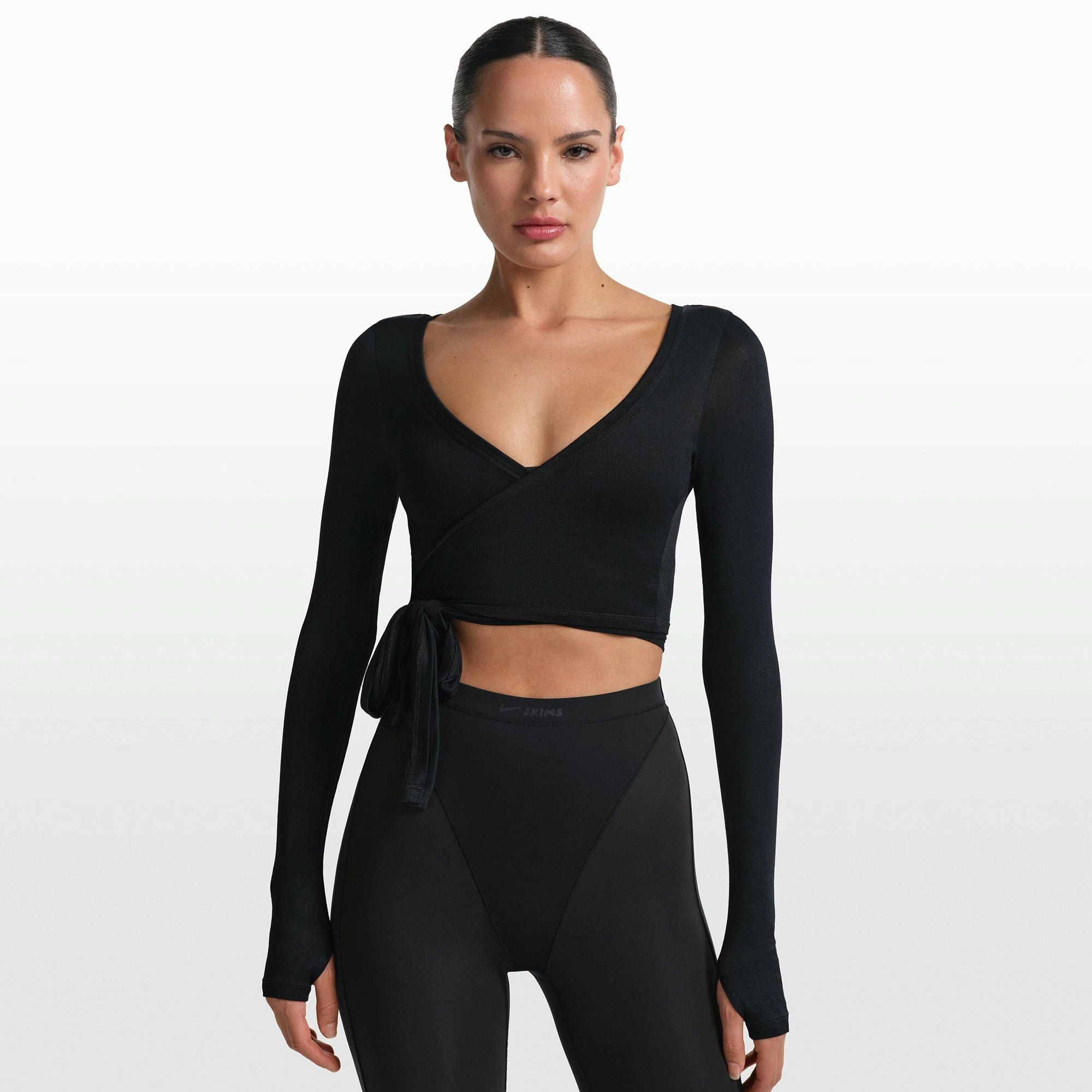 NikeSKIMS STRETCH KNIT WRAP LONG SLEEVE CROPPED TOP | OBSIDIAN ON A MODEL FRONT VIEW @ | FOCUS: 0.0, 1.0, 0.9