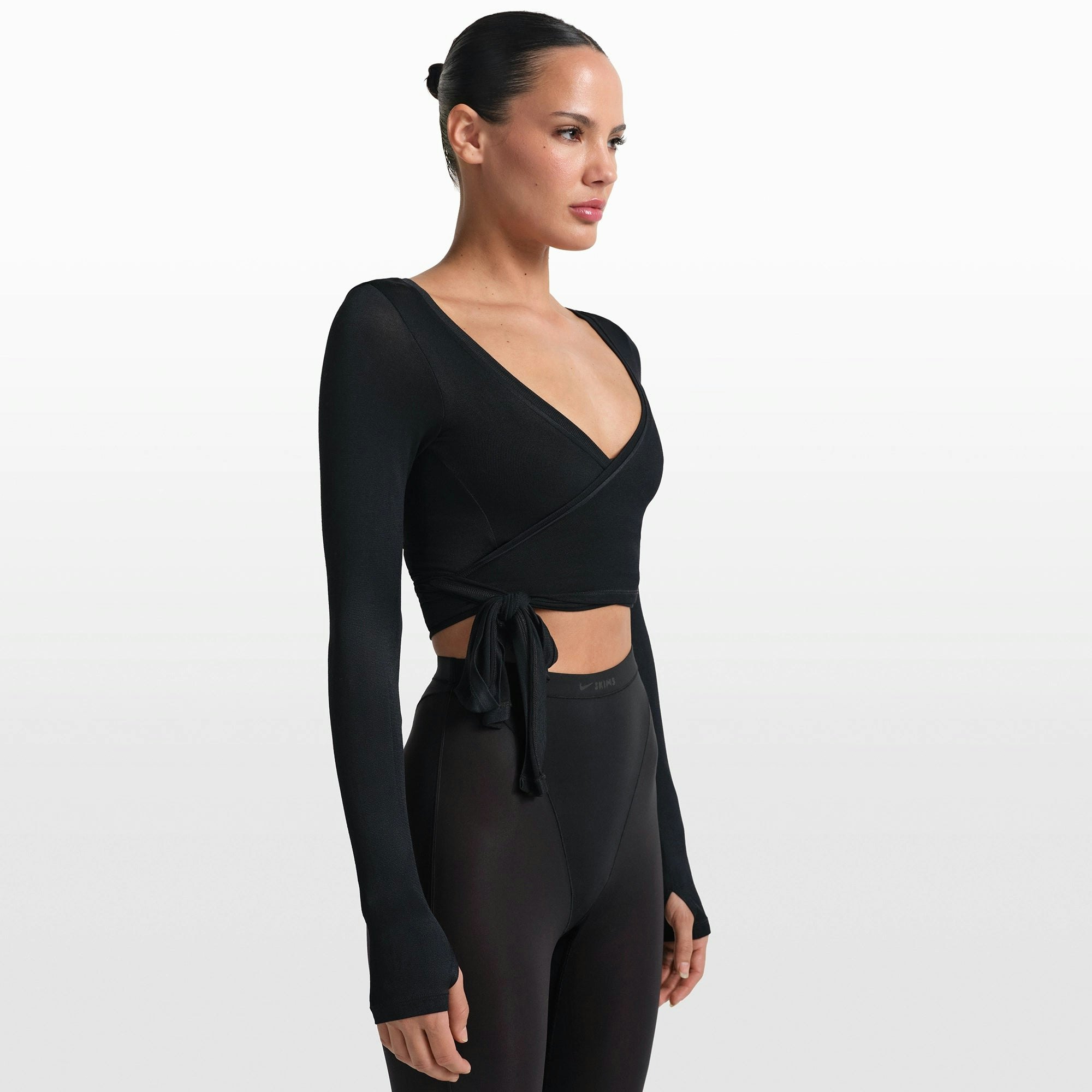 NikeSKIMS STRETCH KNIT WRAP LONG SLEEVE CROPPED TOP | OBSIDIAN ON A MODEL FRONT VIEW @ | FOCUS: 0.0, 1.0, 0.9