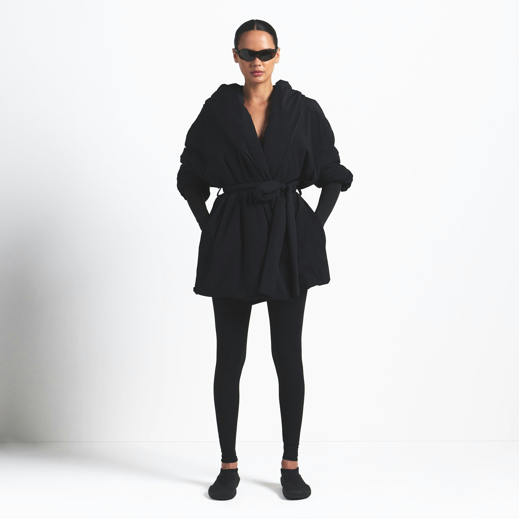 NikeSKIMS WOVEN NYLON WRAP COAT | OBSIDIAN ON A MODEL FRONT VIEW @ | FOCUS: 0.9, 0.1, 0.7