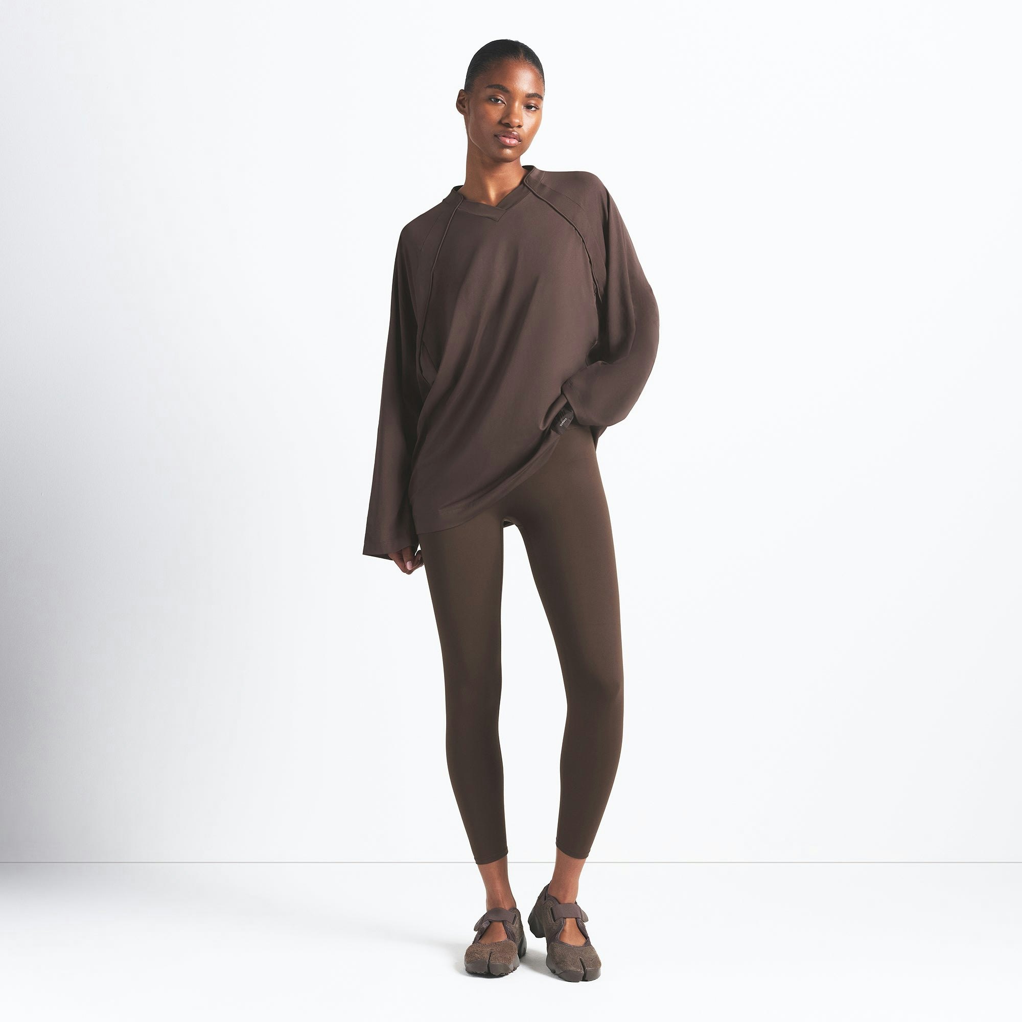 NikeSKIMS AIRY V-NECK OVERSIZED LONG SLEEVE TOP | DARK SEPIA ON A MODEL FRONT VIEW @ | FOCUS: 0.9, 0.1, 0.7