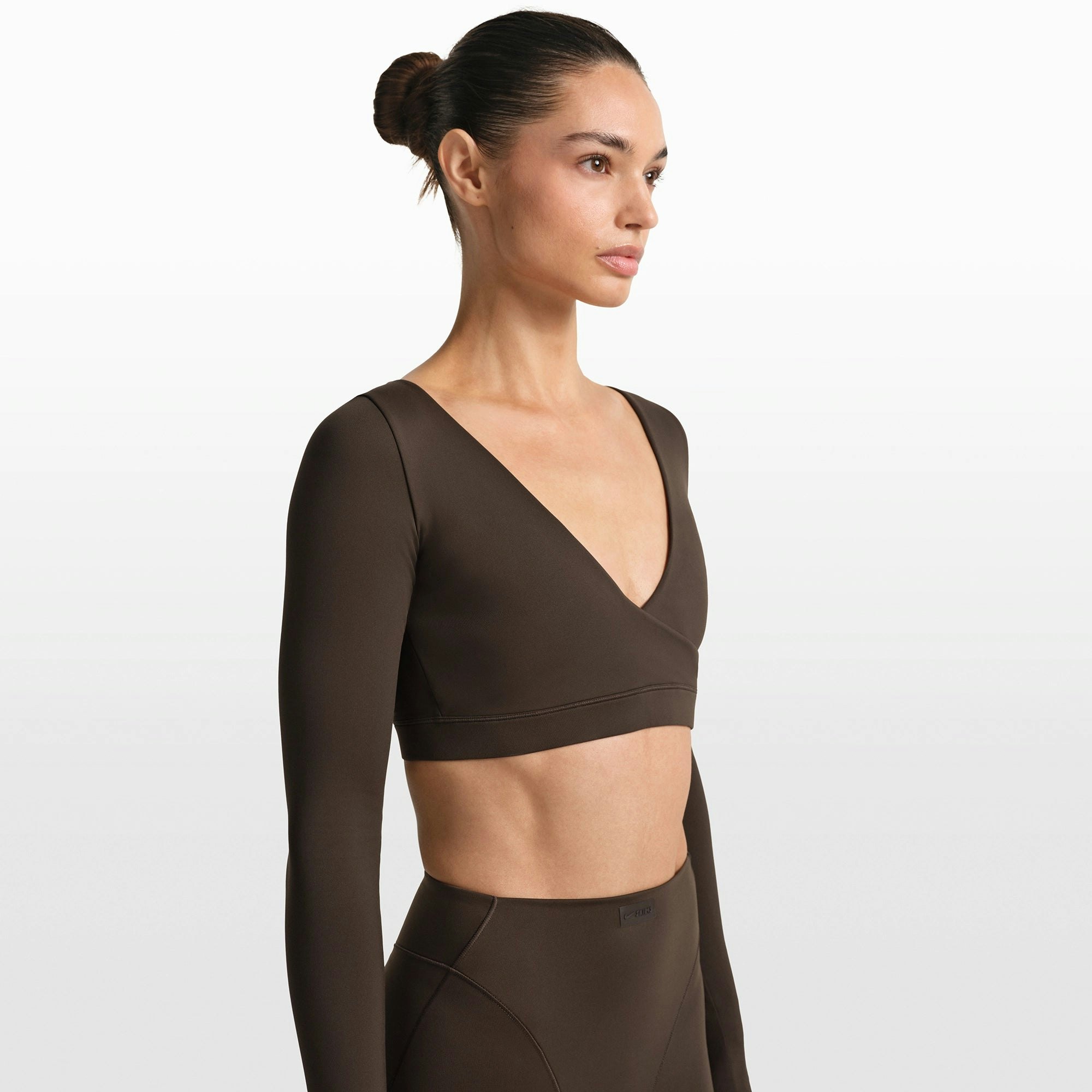 NikeSKIMS MATTE WRAP LONG SLEEVE CROPPED TOP | DARK SEPIA ON A MODEL FRONT VIEW @ | FOCUS: 0.0, 1.0, 0.9
