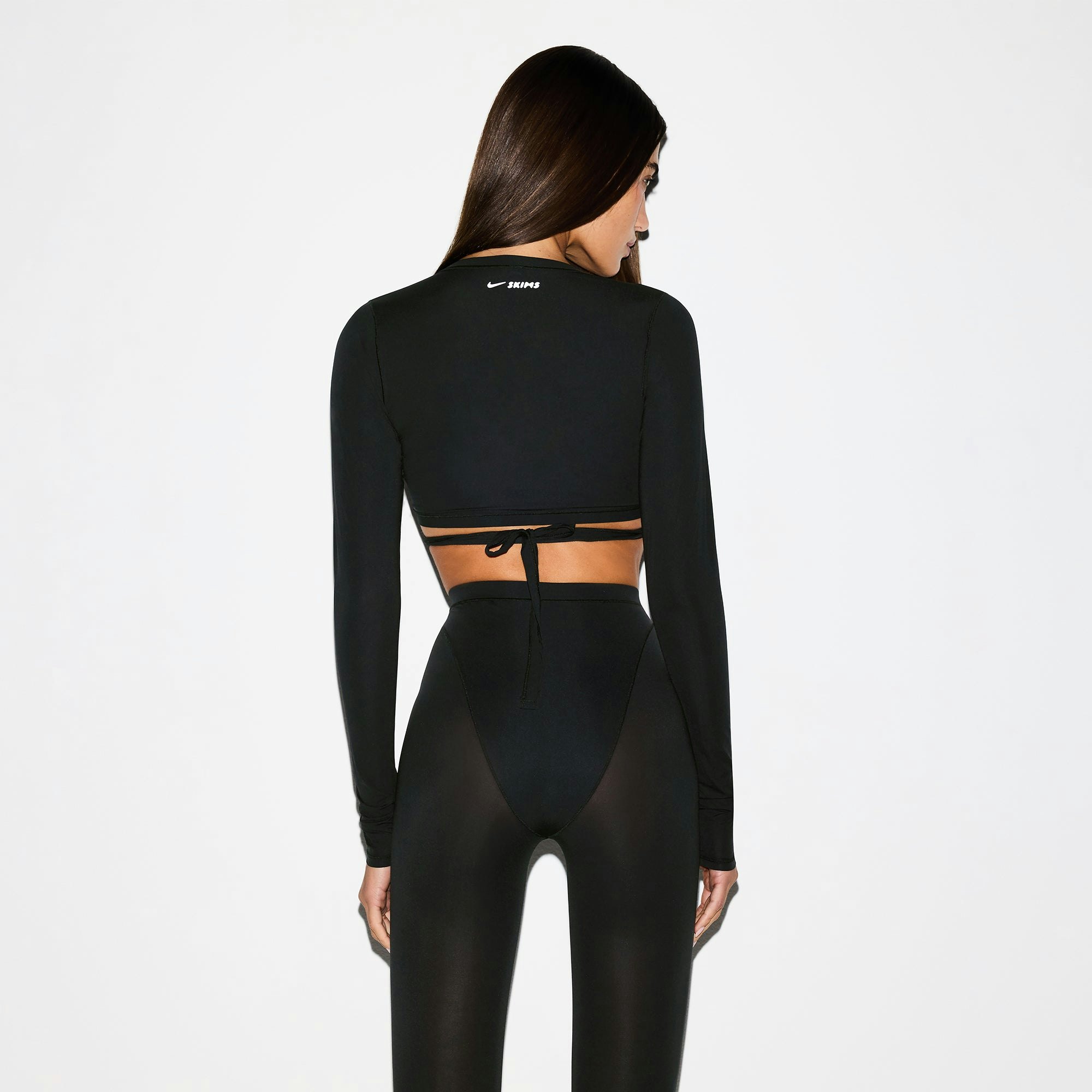 NikeSKIMS WEIGHTLESS LAYERS WRAP TOP | OBSIDIAN ON A MODEL BACK VIEW @ | FOCUS: 0.0, 1.0, 0.9