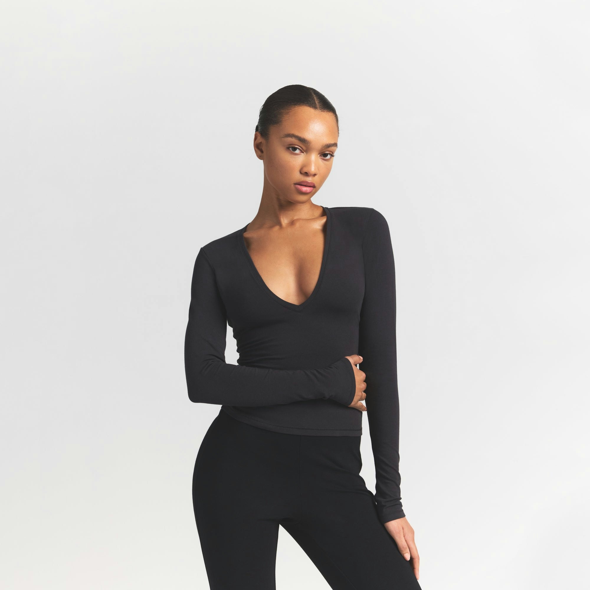 COTTON JERSEY LONG SLEEVE DEEP PLUNGE TOP | SOOT ON A MODEL FRONT VIEW @ | FOCUS: 0.9, 0.1, 0.7