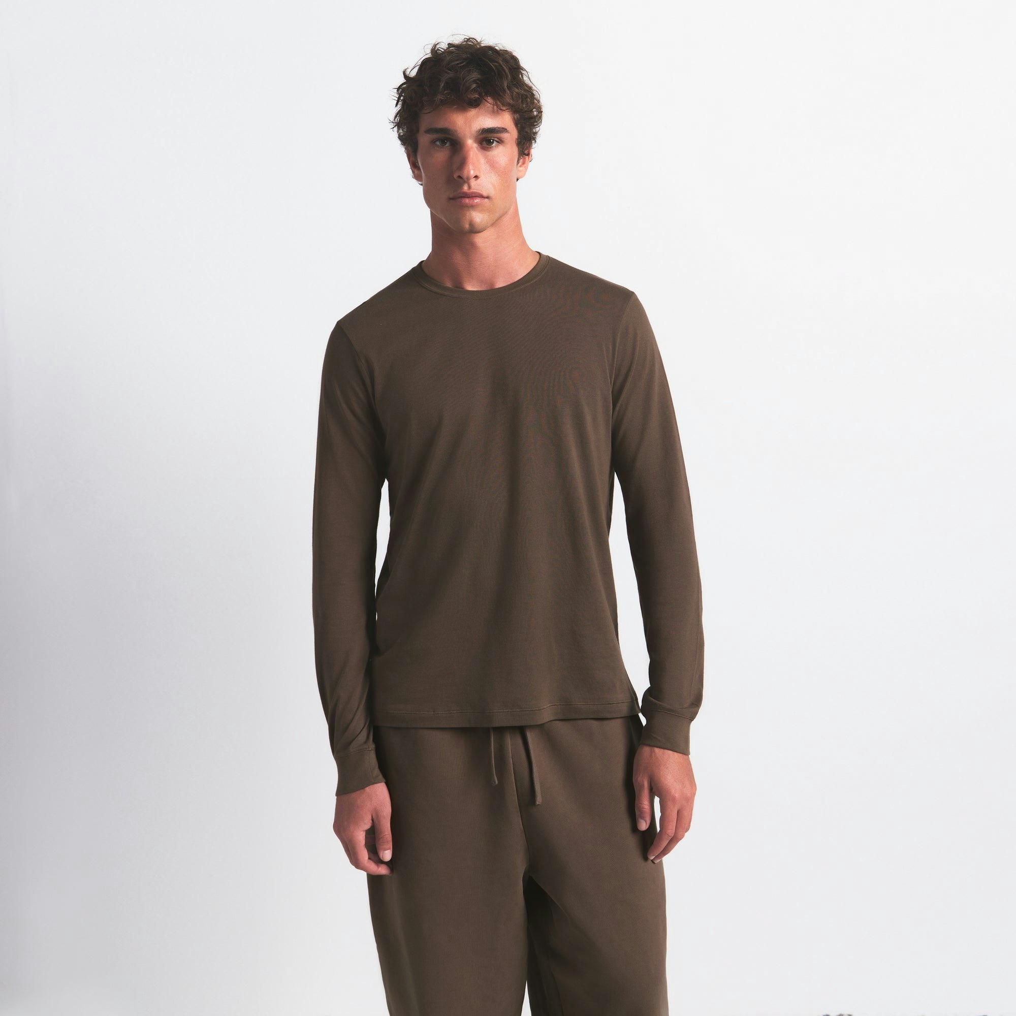 SKIMS COTTON MENS CLASSIC LONG SLEEVE T-SHIRT | DRIFTWOOD ON A MODEL FRONT VIEW @ | FOCUS: 0.0, 1.0, 0.9