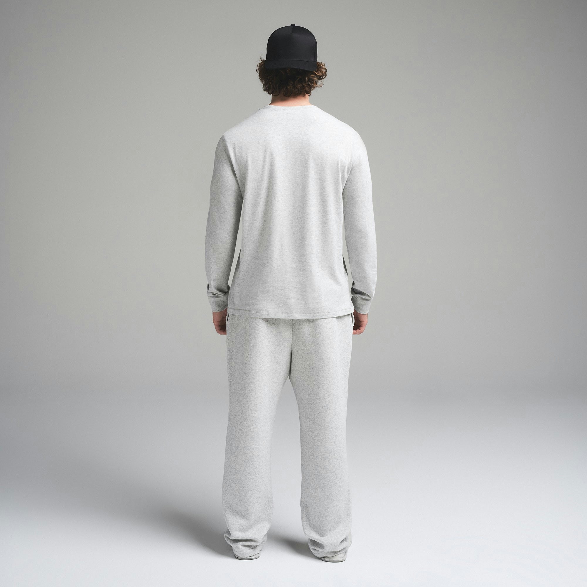 SKIMS COTTON MENS CLASSIC LONG SLEEVE T-SHIRT | LIGHT HEATHER GREY ON A MODEL SIDE VIEW | FOCUS: 0.0, 1.0, 0.9