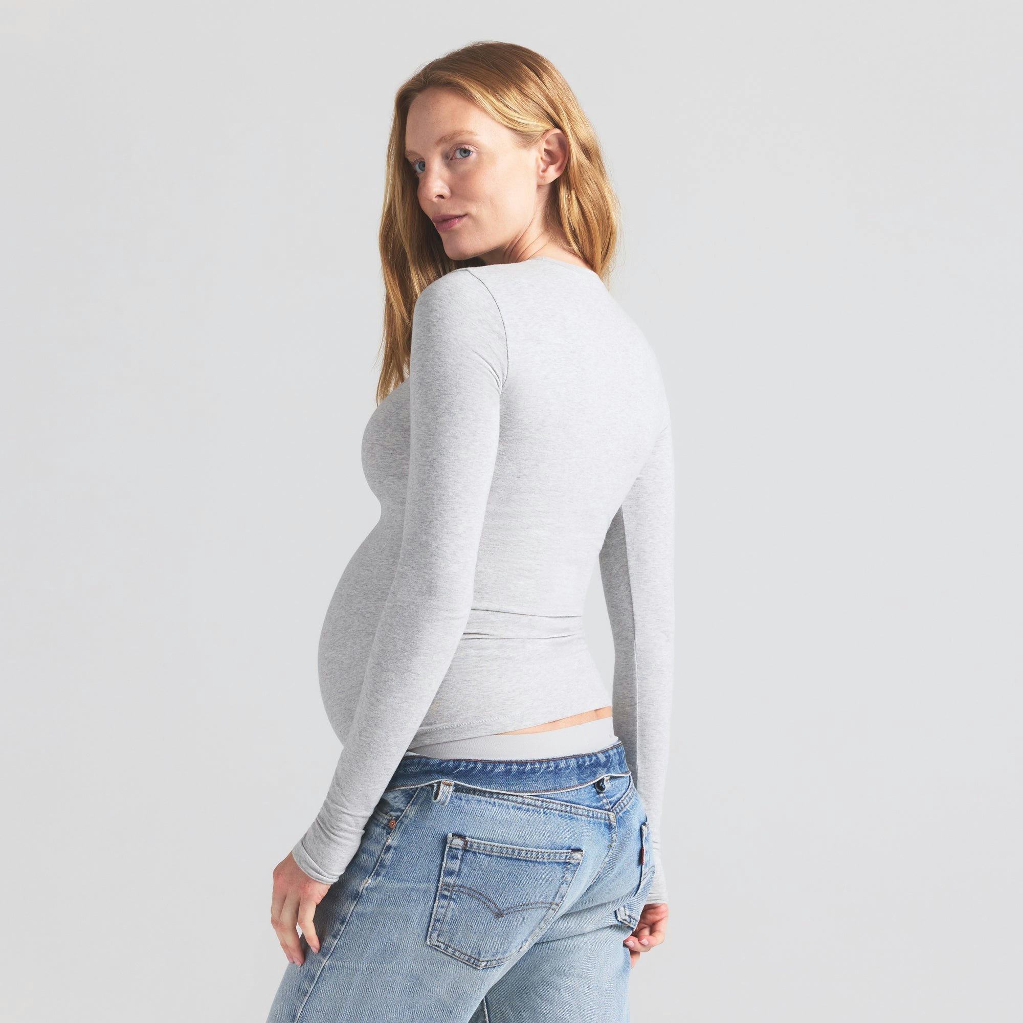 COTTON JERSEY MATERNITY LONG SLEEVE T-SHIRT | LIGHT HEATHER GREY ON A MODEL SIDE VIEW | FOCUS: 0.9, 0.1, 0.7