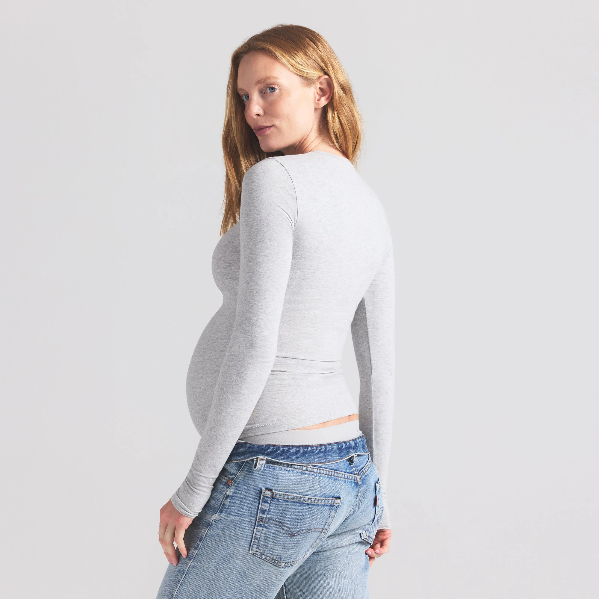 COTTON JERSEY MATERNITY LONG SLEEVE T-SHIRT | LIGHT HEATHER GREY ON A MODEL SIDE VIEW | FOCUS: 0.9, 0.1, 0.7