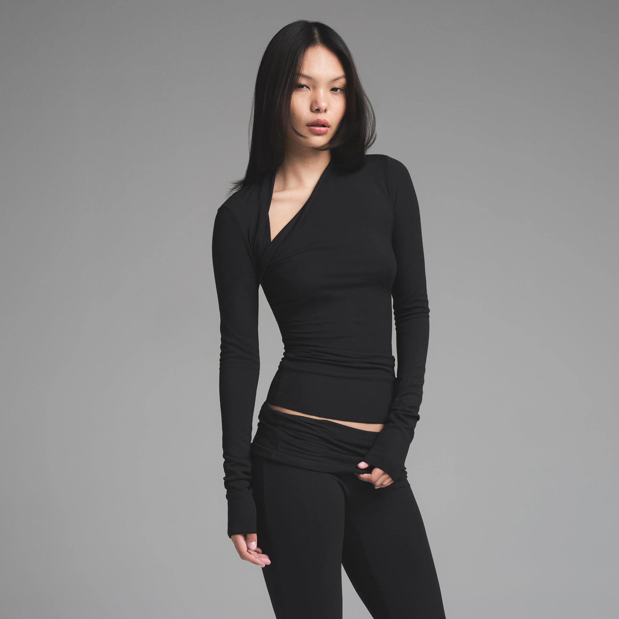 SKIMS CLOUD ASYMMETRIC LONG SLEEVE TOP | ONYX ON A MODEL FRONT VIEW | FOCUS: 0.0, 1.0, 0.9