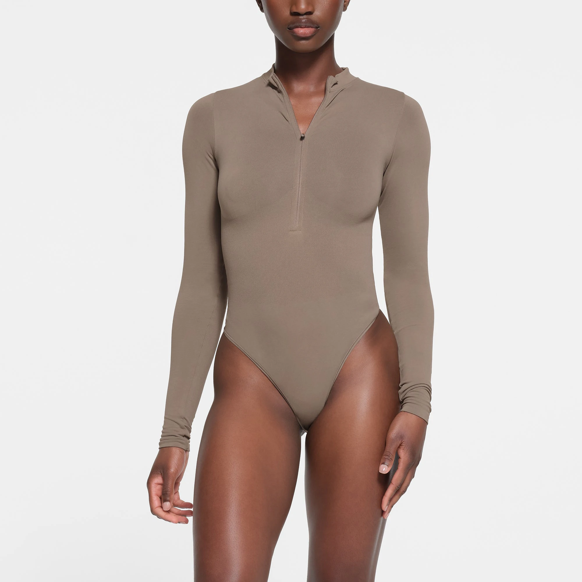 CONTOUR NYLON ZIP FRONT LONG SLEEVE BODYSUIT | TRUFFLE ON A MODEL FRONT VIEW