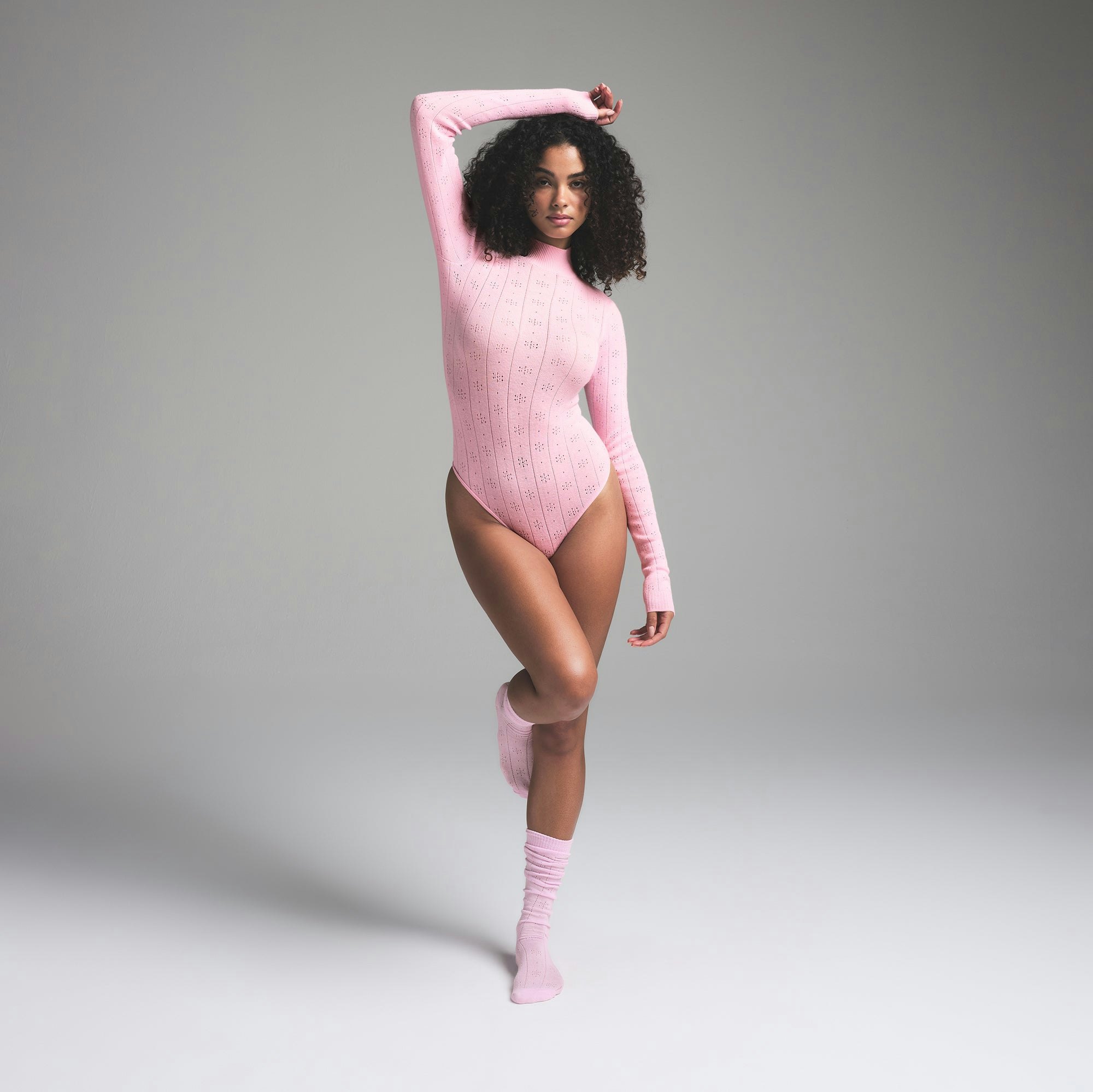 SWEATER POINTELLE TURTLENECK BODYSUIT | BABY PINK ON A MODEL FRONT VIEW | FOCUS: 0.0, 1.0, 0.9