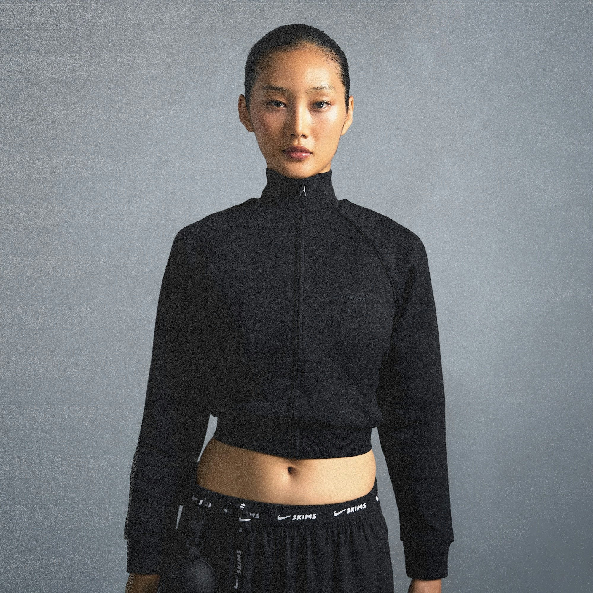 NikeSKIMS MATTE TRICOT TRACK JACKET | OBSIDIAN ON A MODEL SIDE VIEW @ | FOCUS: 0.0, 1.0, 0.9