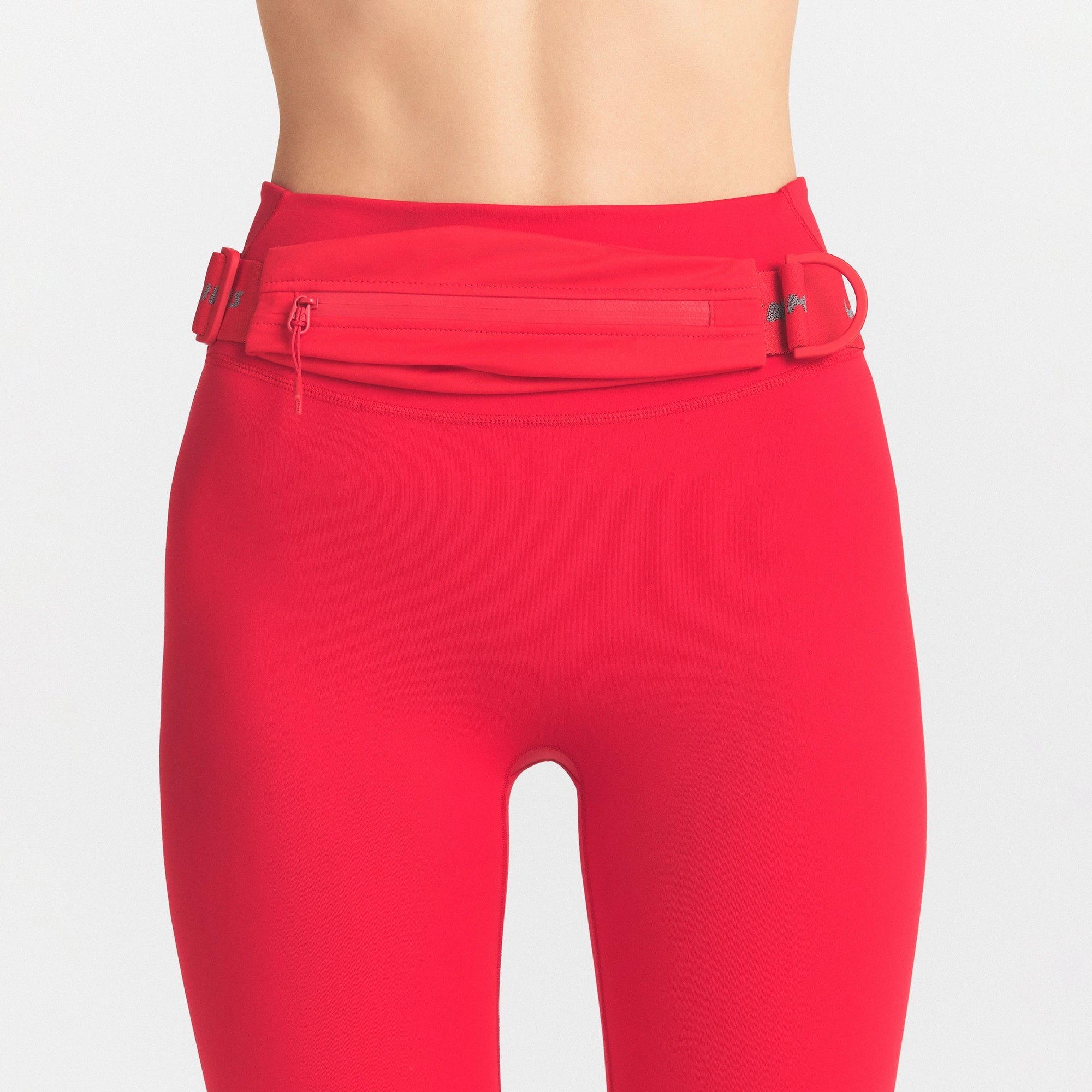 NIKESKIMS ACCESSORIES SLIM WAISTPACK | UNIVERSITY RED & LAYS FLAT ON A WHITE BACKGROUND | FLT