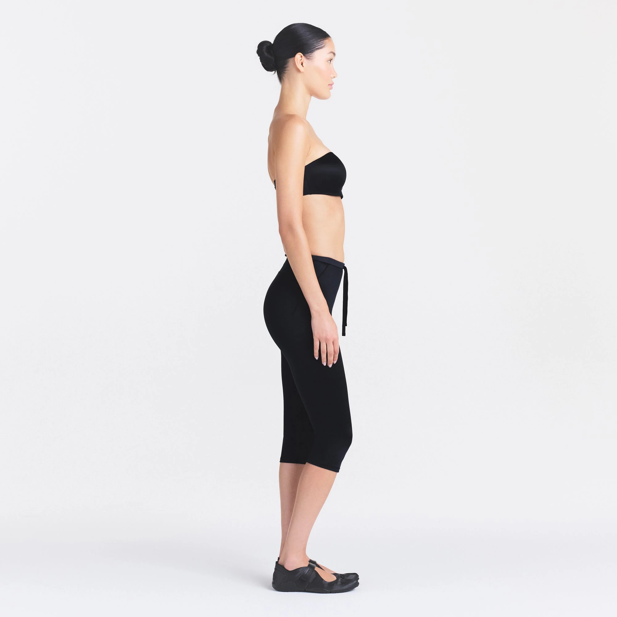 NikeSKIMS SATIN SHINE CAPRI 17" LEGGING | OBSIDIAN ON A MODEL FRONT VIEW