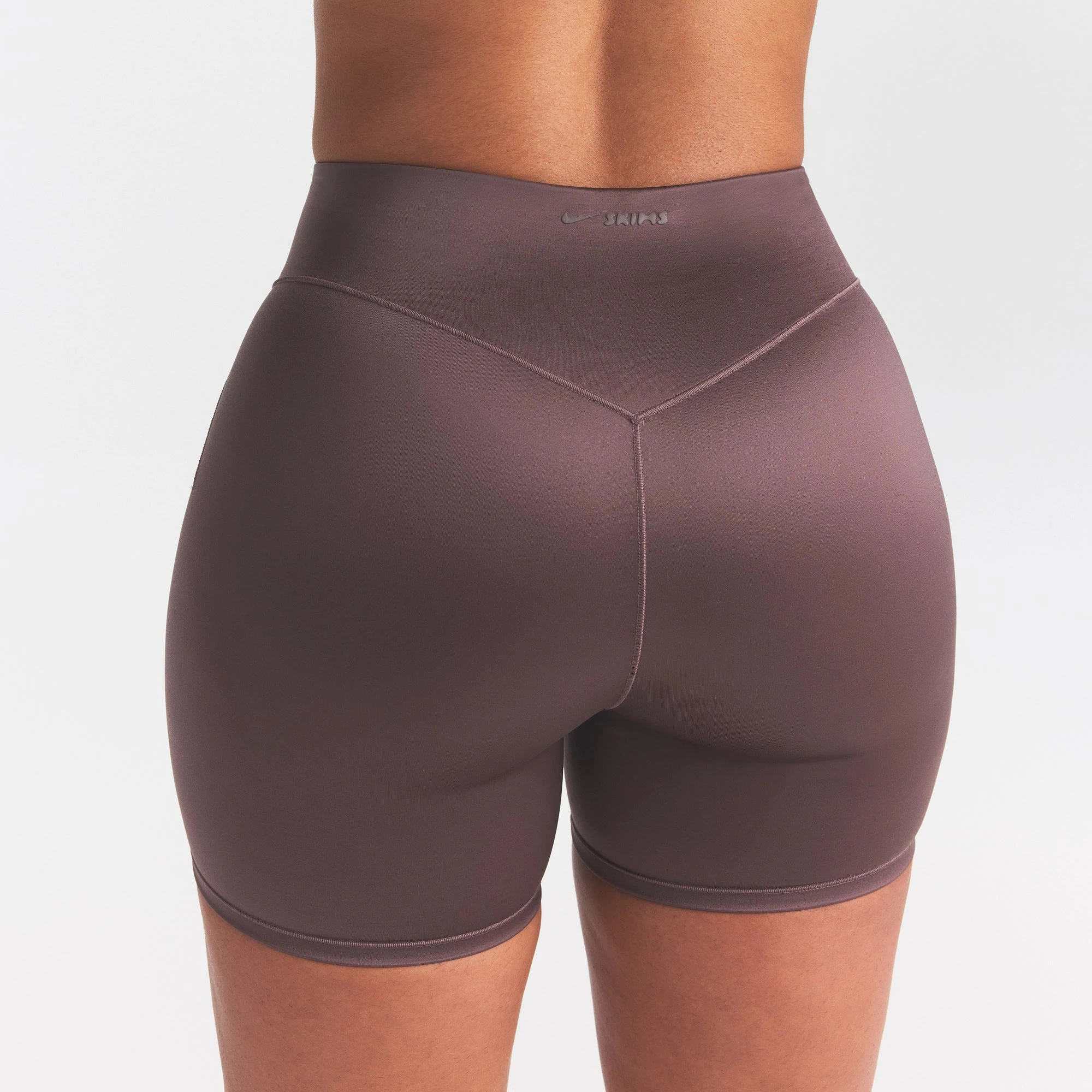 NikeSKIMS SATIN SHINE BONDED WAIST 5" BIKER SHORT | RESIN ON A MODEL SIDE VIEW