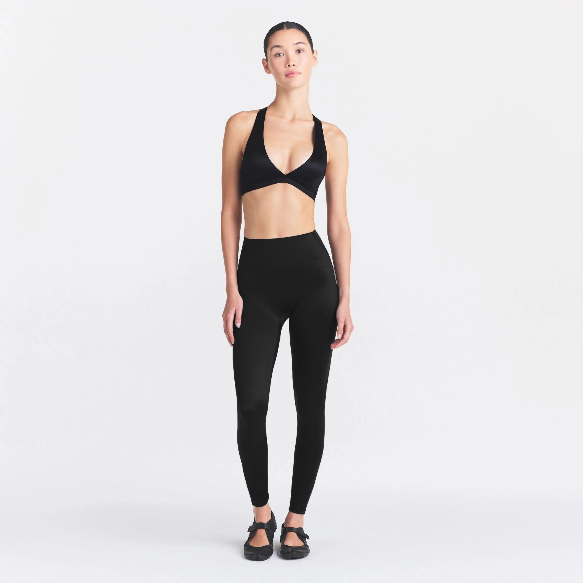 NikeSKIMS SATIN SHINE BONDED WAIST 26" LEGGING | OBSIDIAN ON A MODEL FRONT VIEW