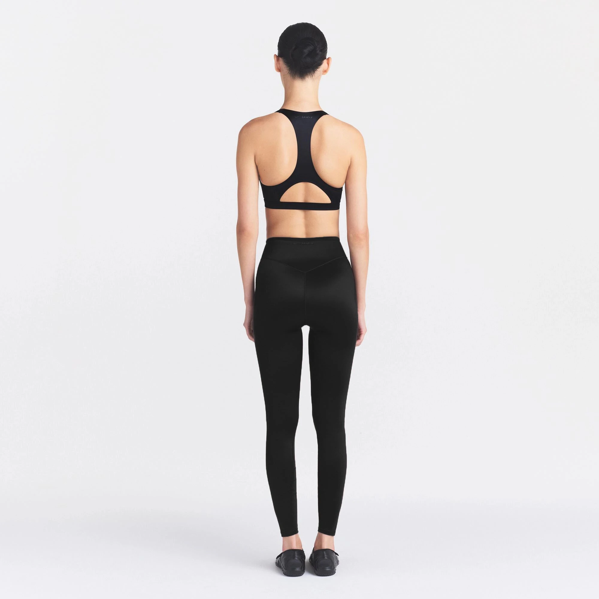 NikeSKIMS SATIN SHINE BONDED WAIST 26" LEGGING | OBSIDIAN ON A MODEL FRONT VIEW